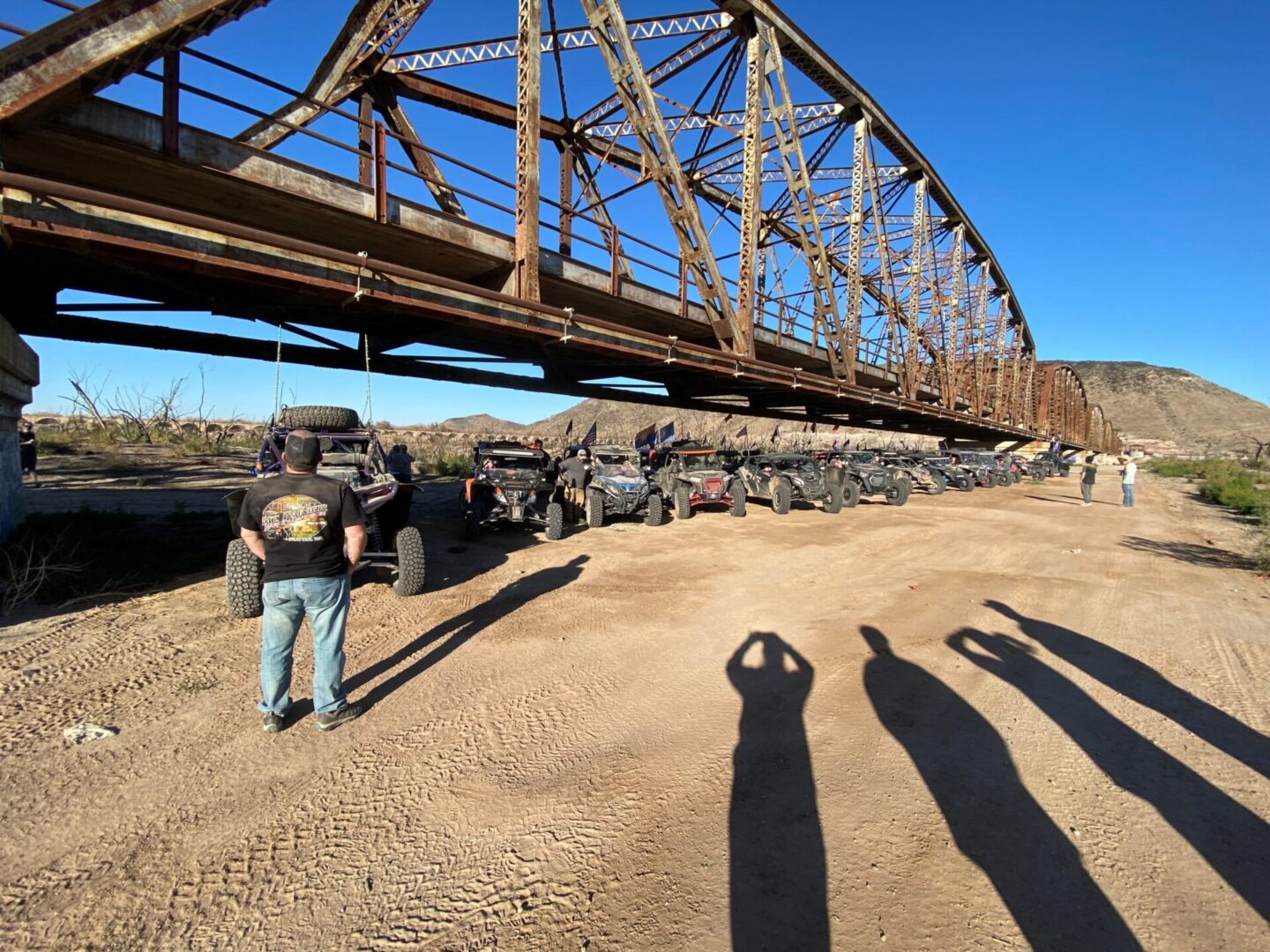 A man standing in front of an old bridge.