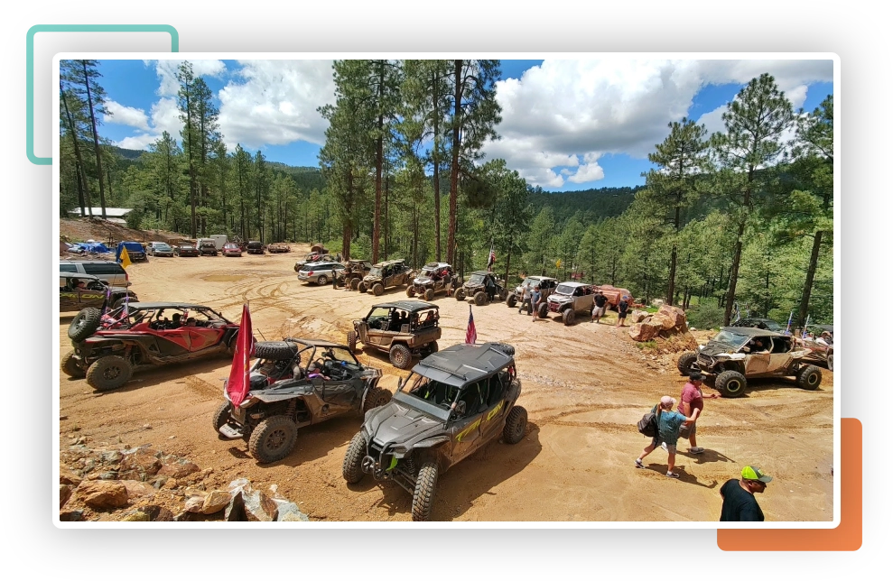 A group of off road vehicles parked in the mud.