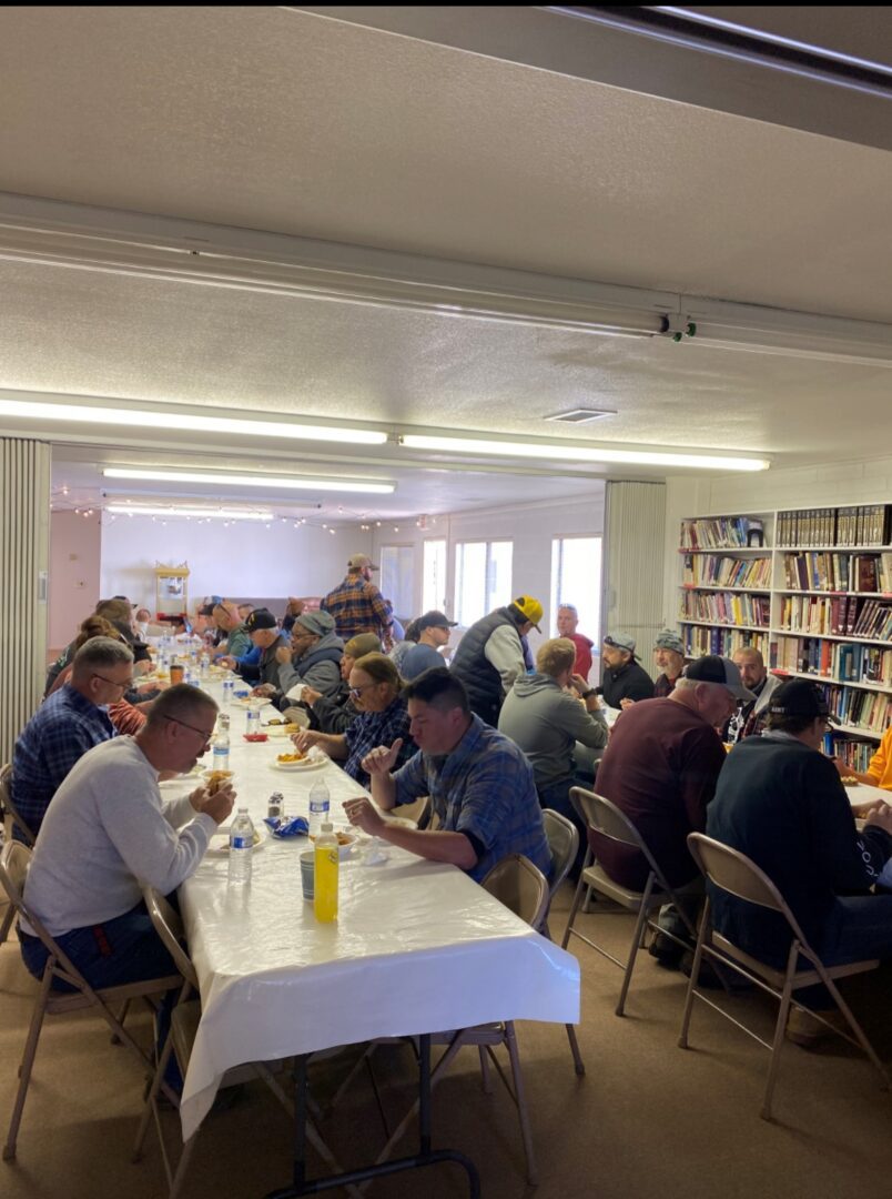 A group of people sitting at tables eating food.