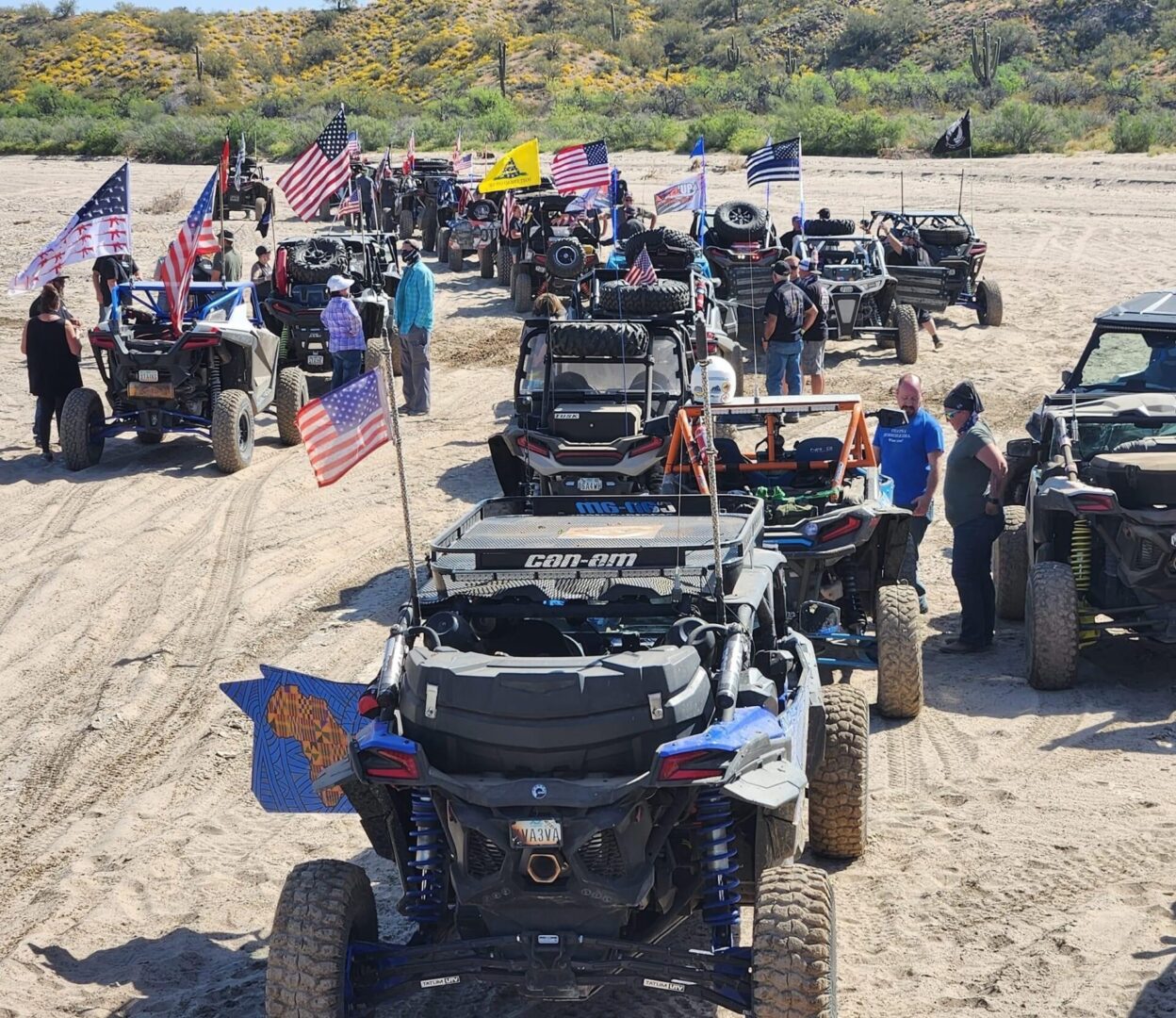 A group of people standing around parked vehicles.