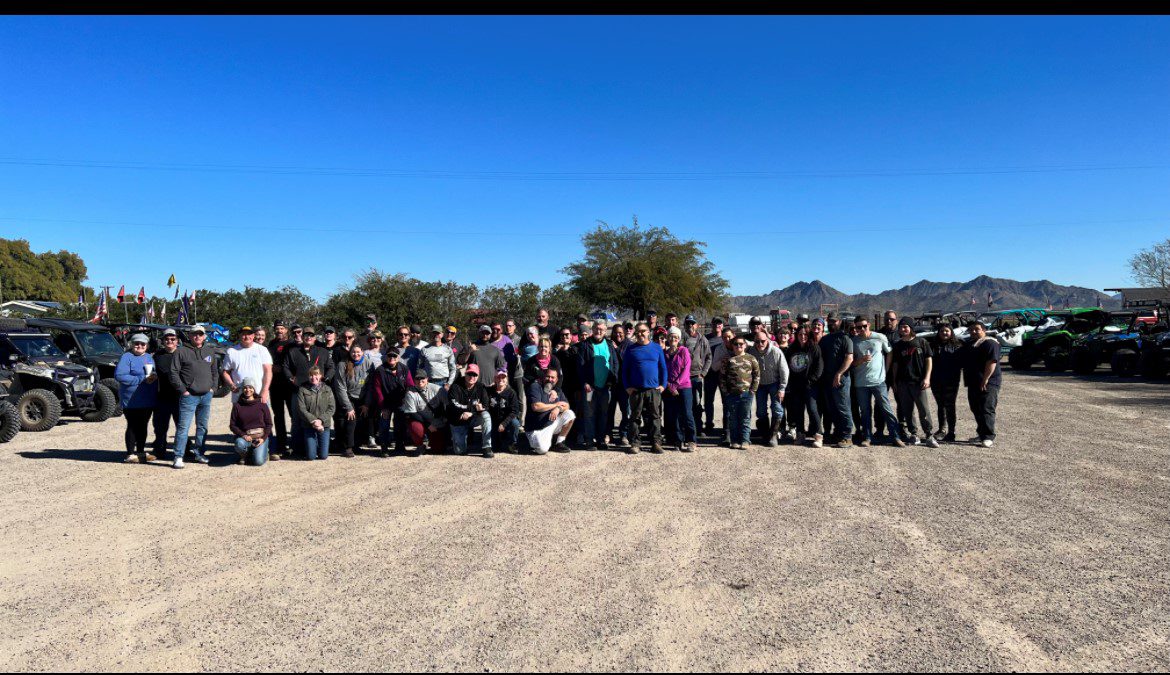 A group of people standing in the dirt.