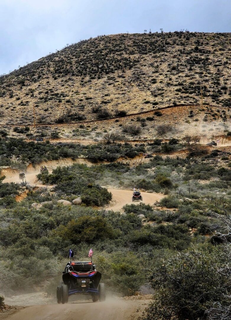 A car driving down the road in the desert.