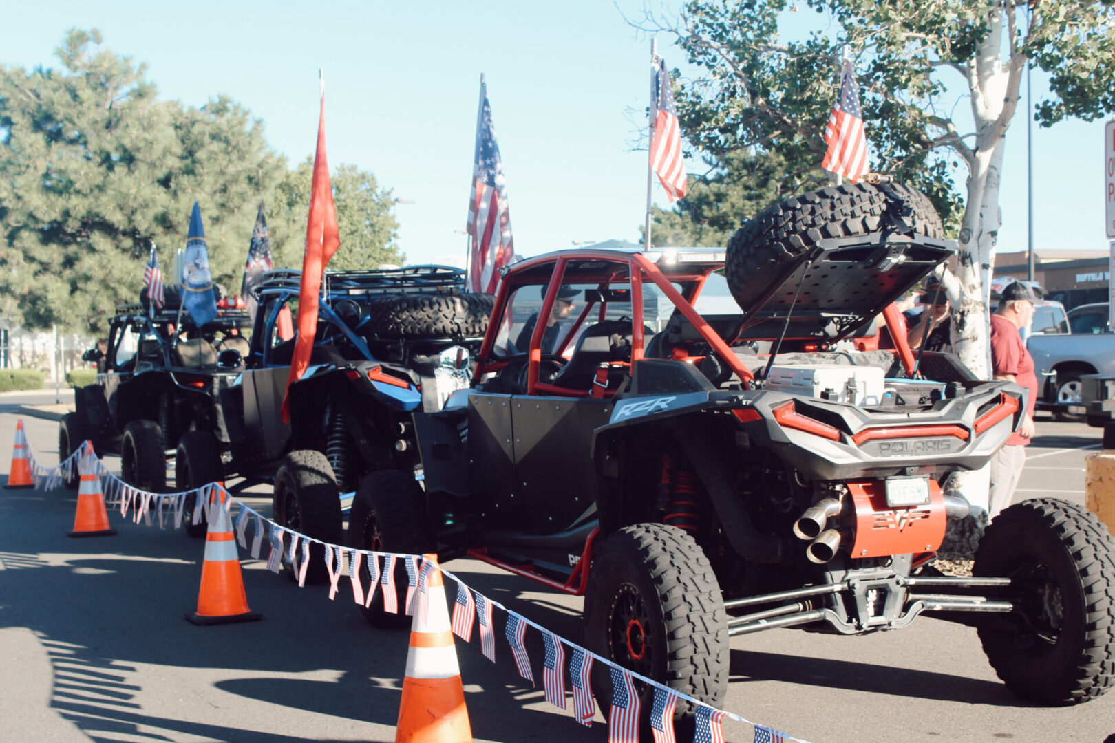 A group of people standing around an off road vehicle.