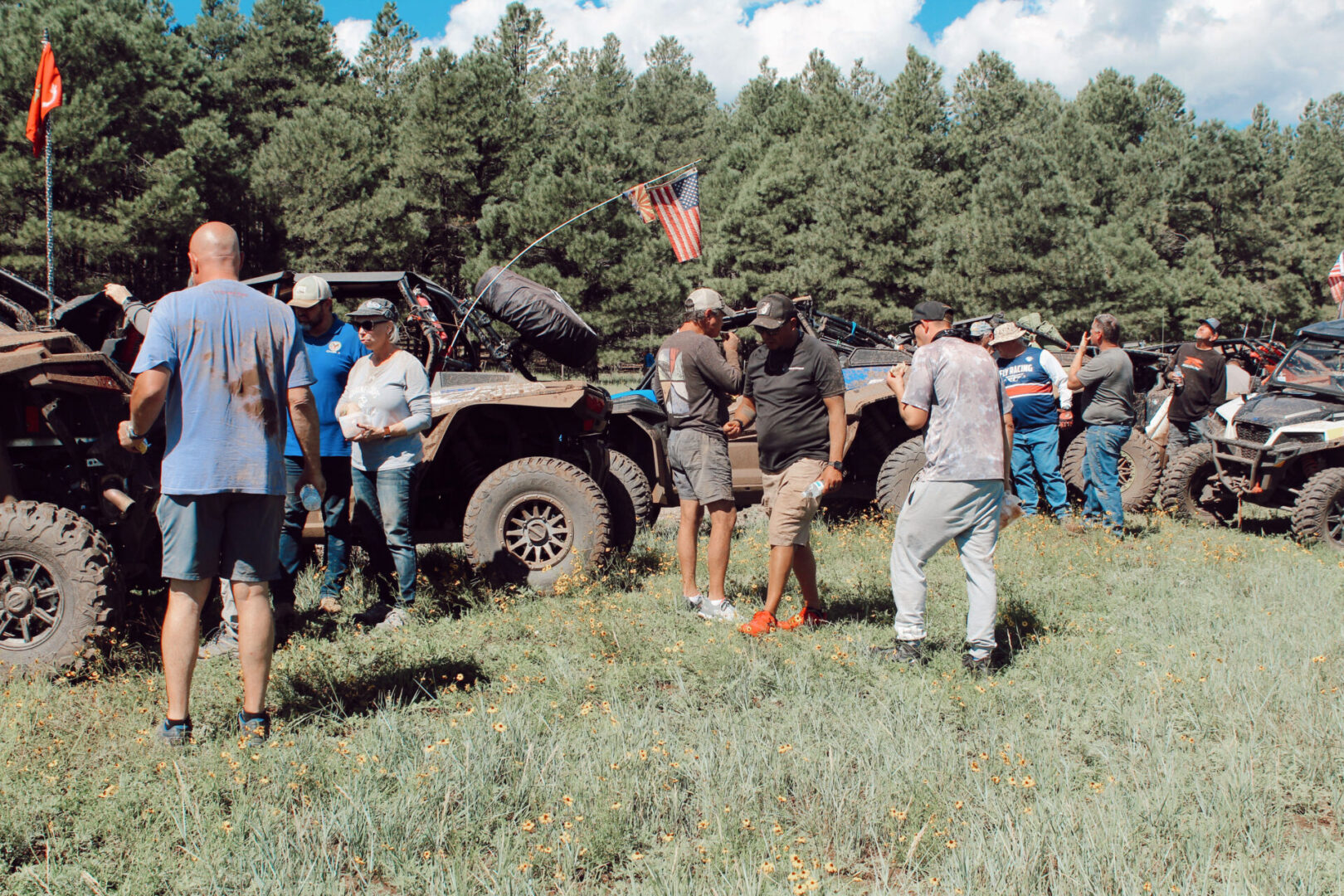 A group of people standing around an old jeep.