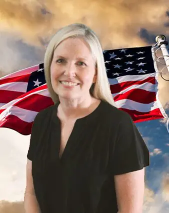 A woman standing in front of an american flag.