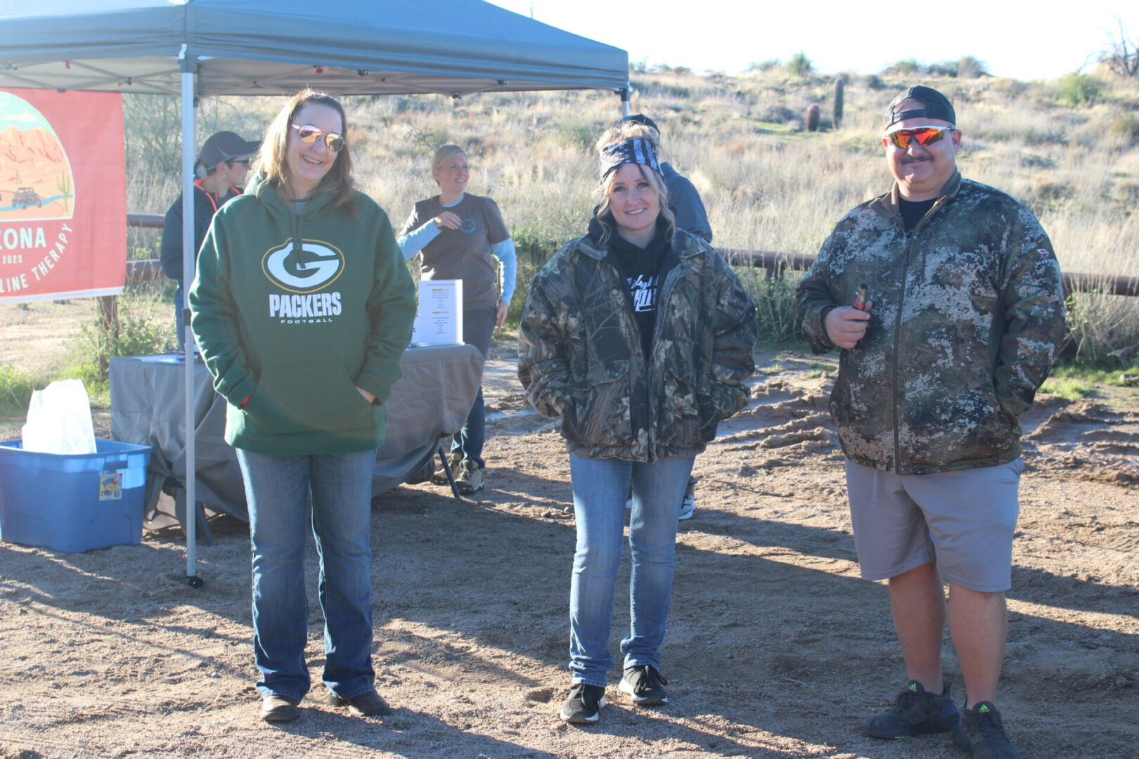 A group of people standing in the dirt.