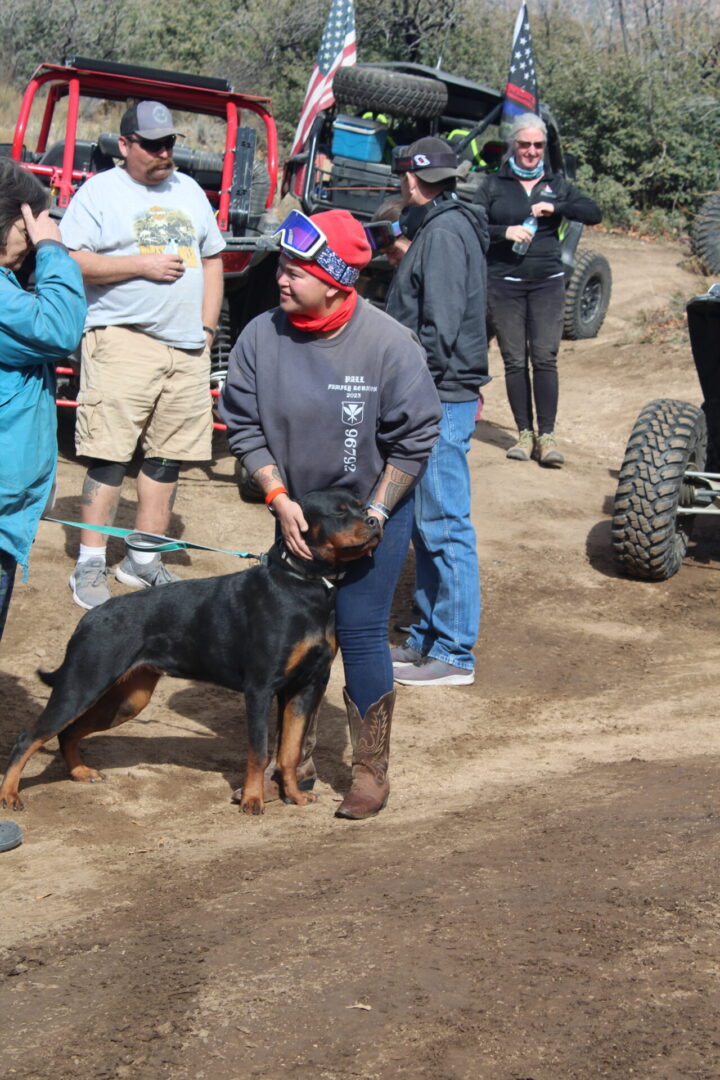 A man and his dog are on the dirt.