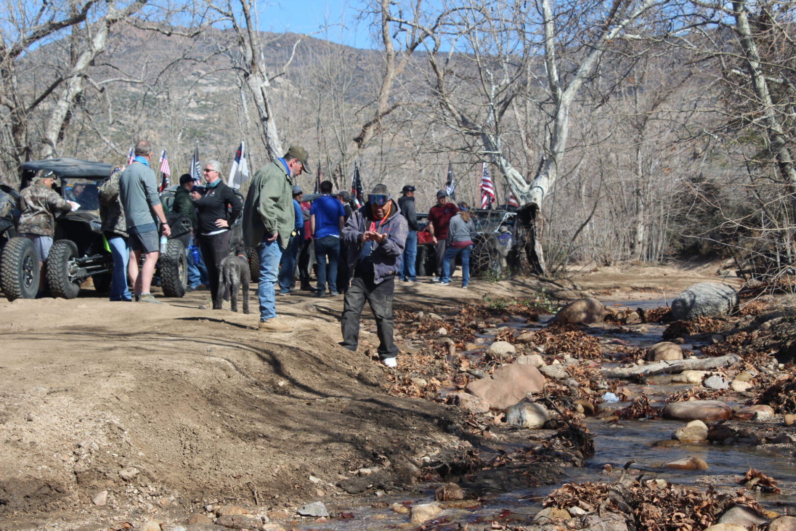 A group of people standing around a stream.