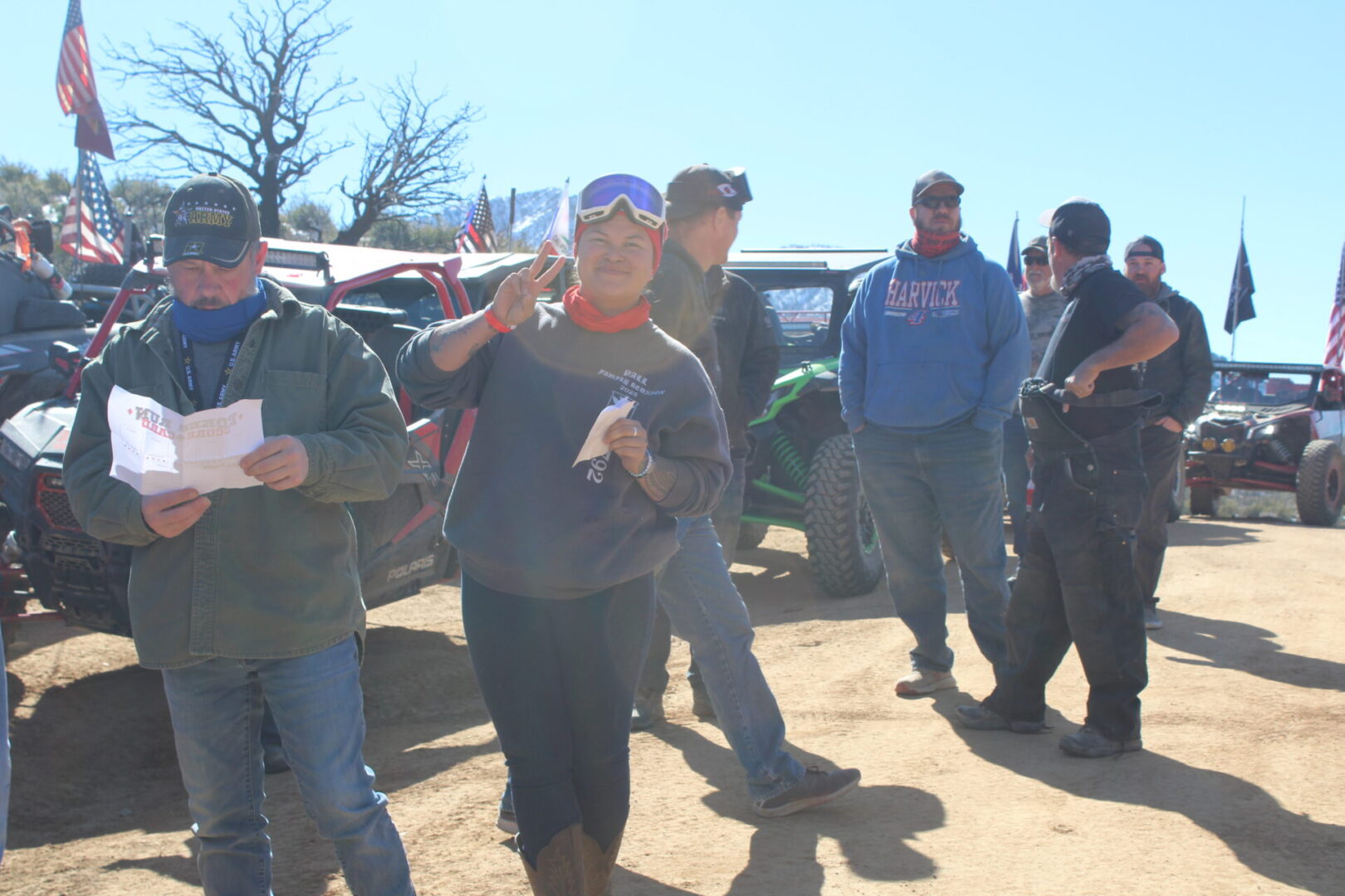 A group of people standing around in the dirt.