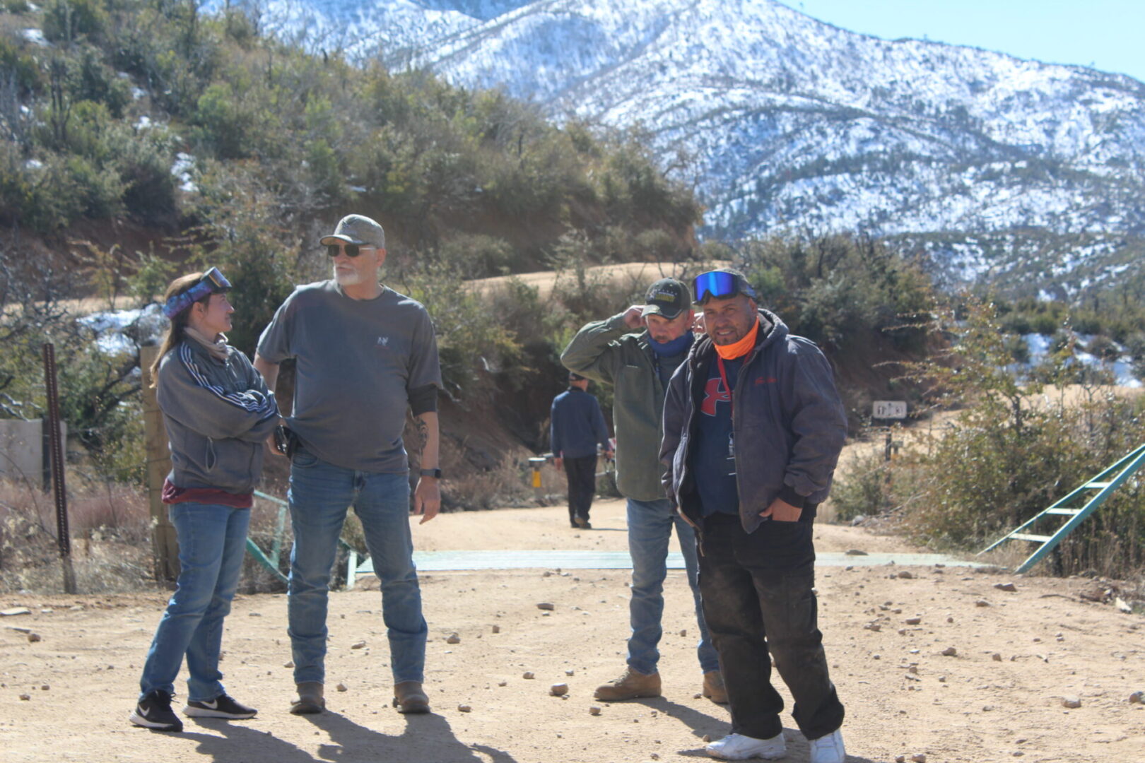 A group of men standing on top of a dirt road.