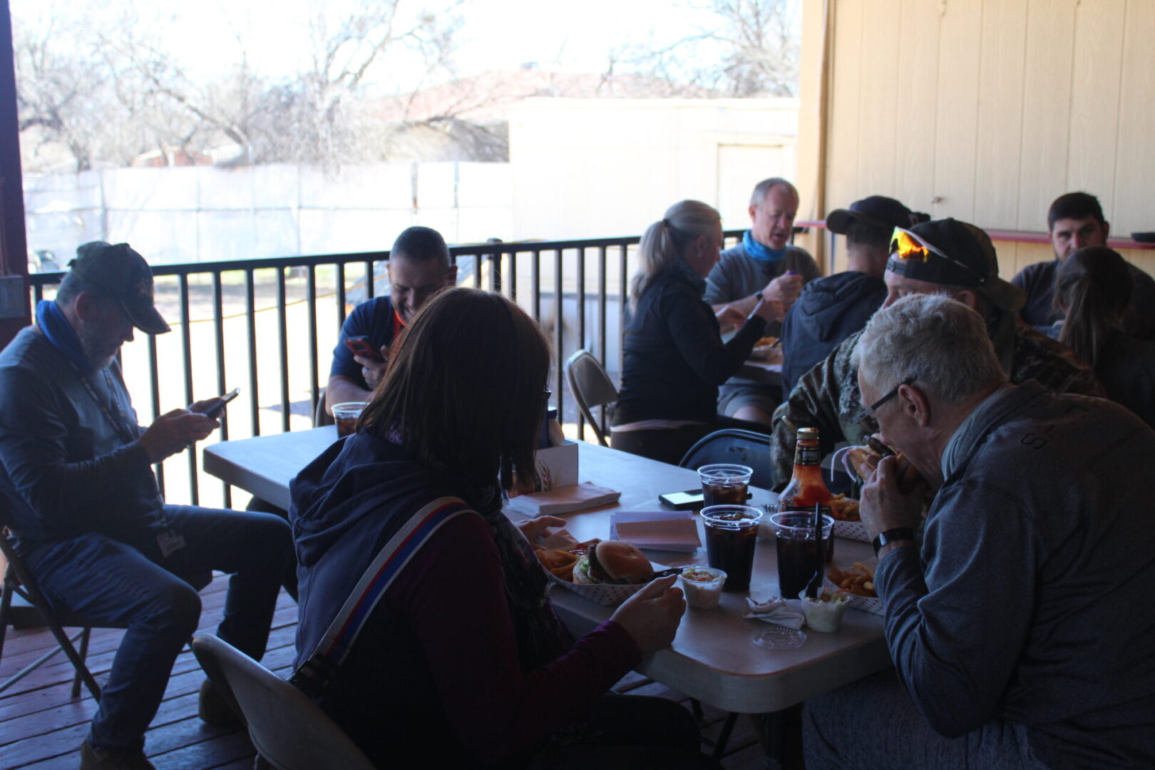 A group of people sitting at tables eating food.