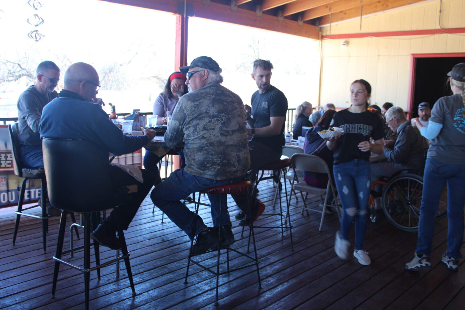 A group of people sitting at tables in front of a window.