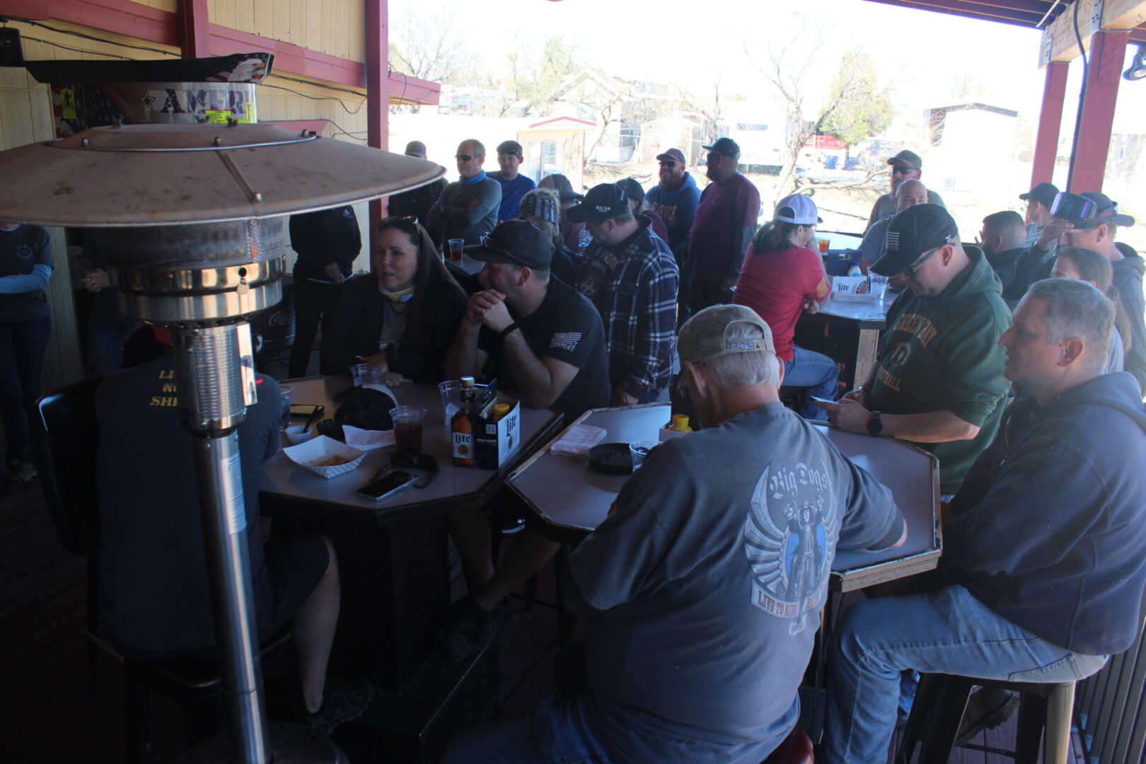 A group of people sitting at tables eating food.