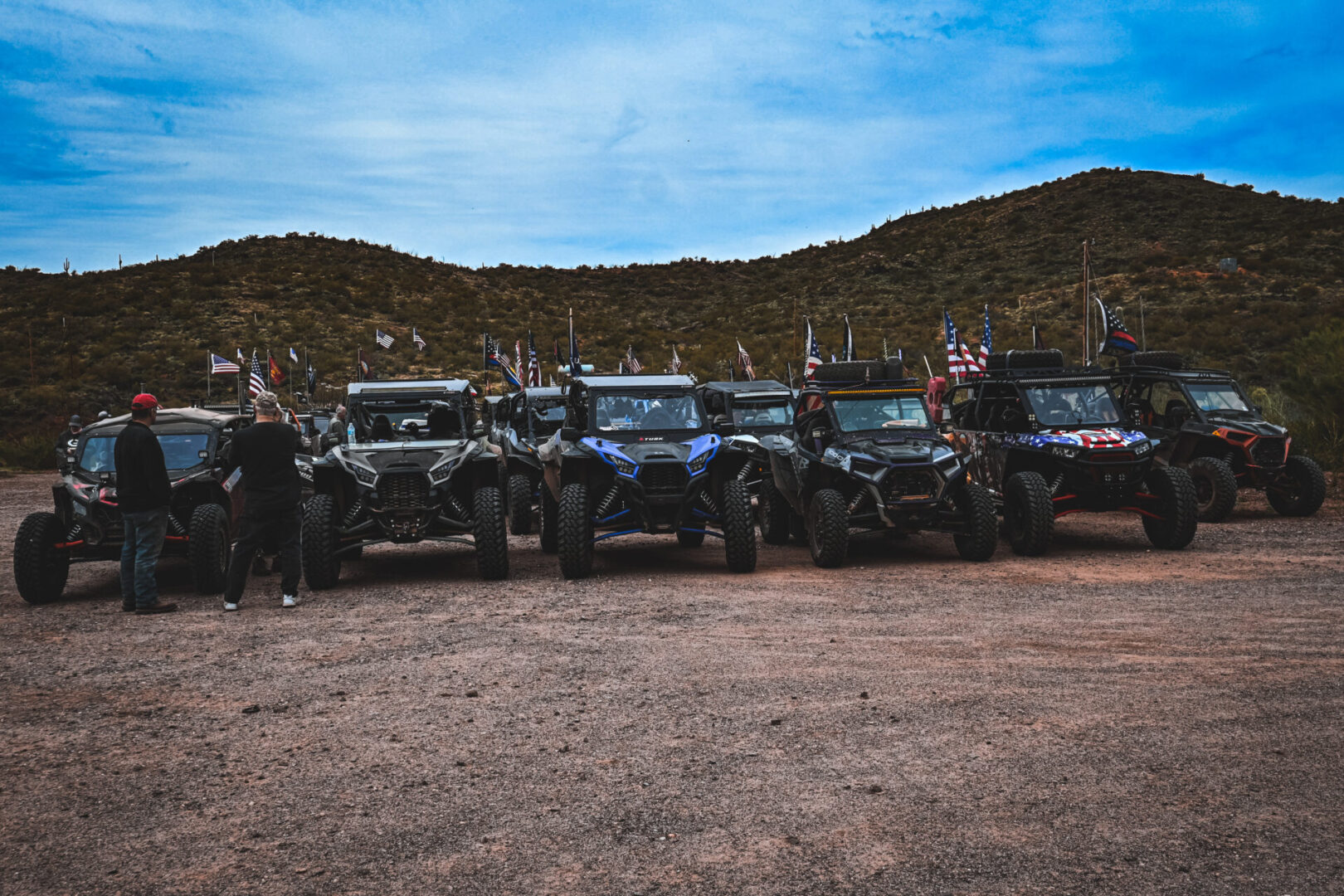 A group of four wheel drive vehicles parked in the dirt.