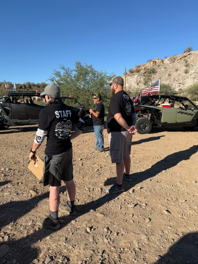 Event staff near off-road UTVs in desert