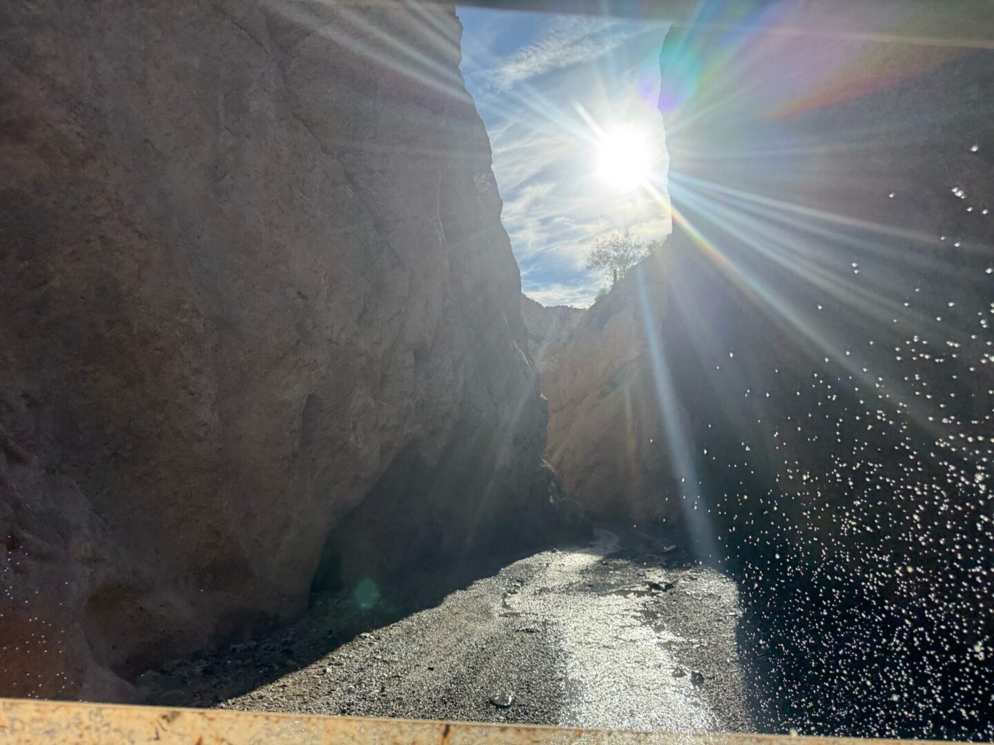Sunlit canyon with stream and water spray