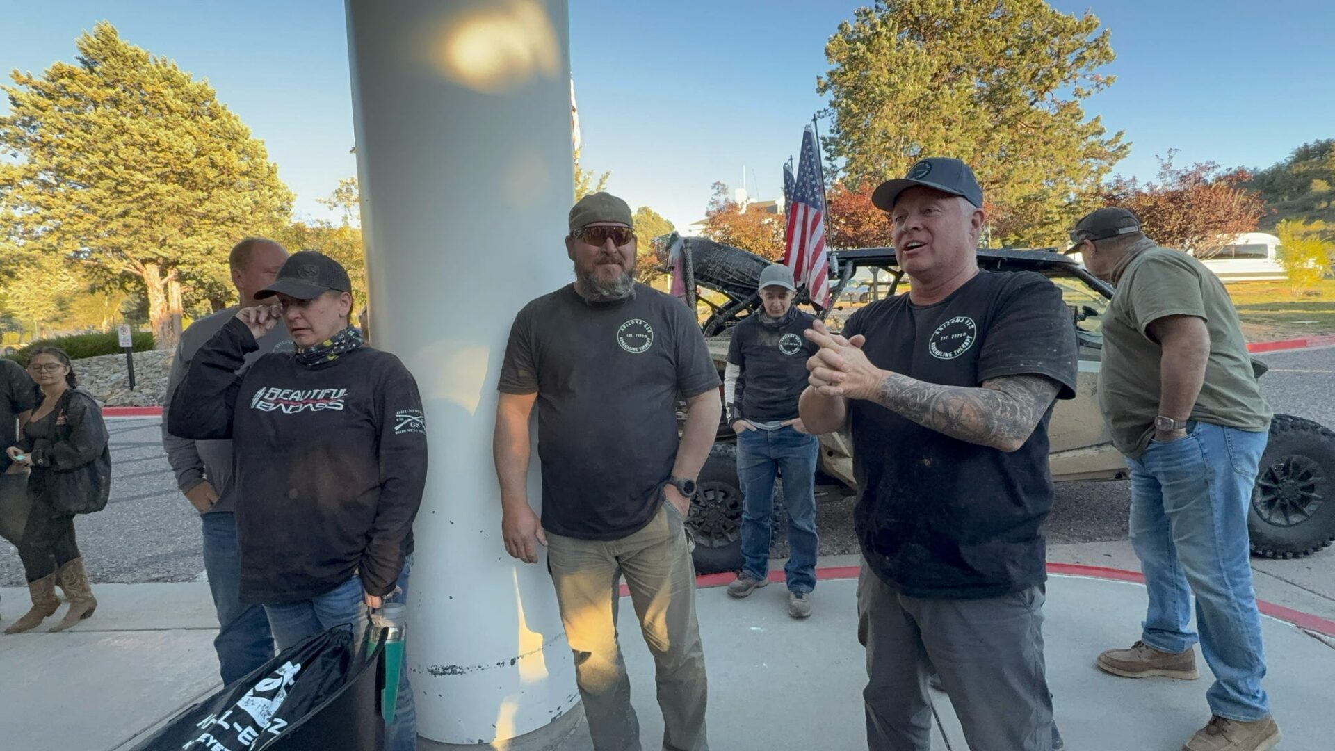 Group of men gathered outdoors with American flag