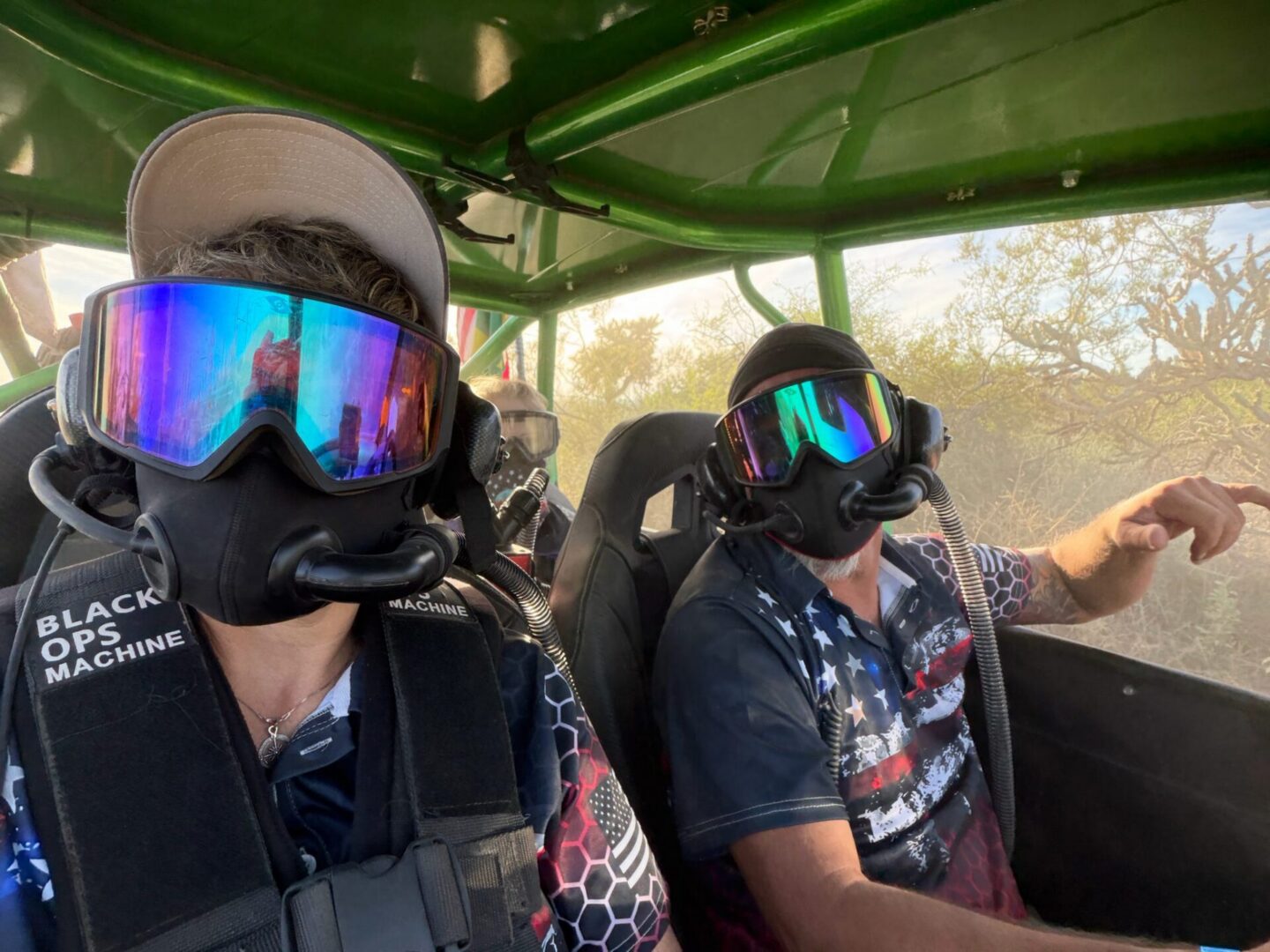 Two riders wearing goggles in off-road UTV
