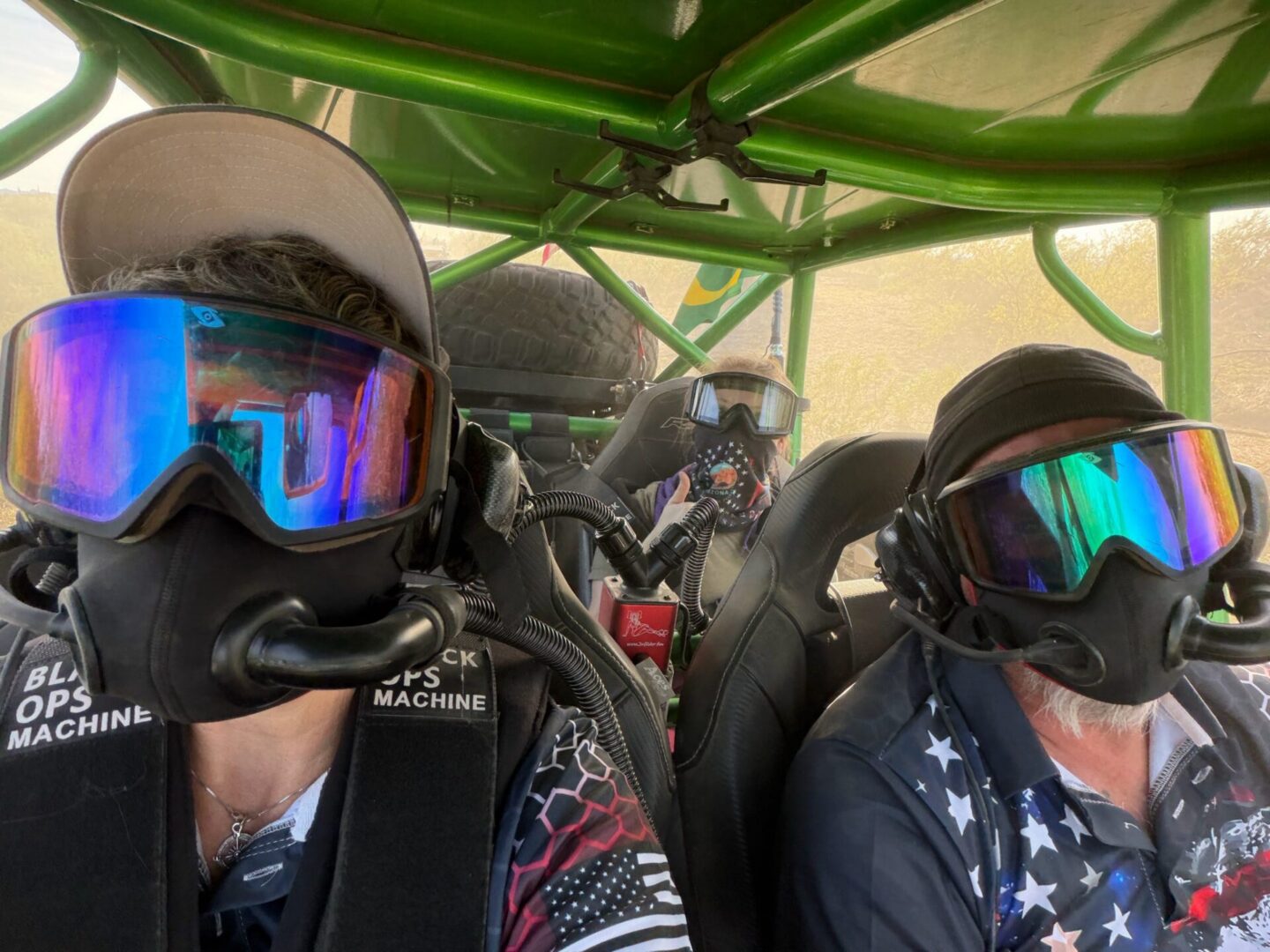 Three masked riders in green off-road buggy