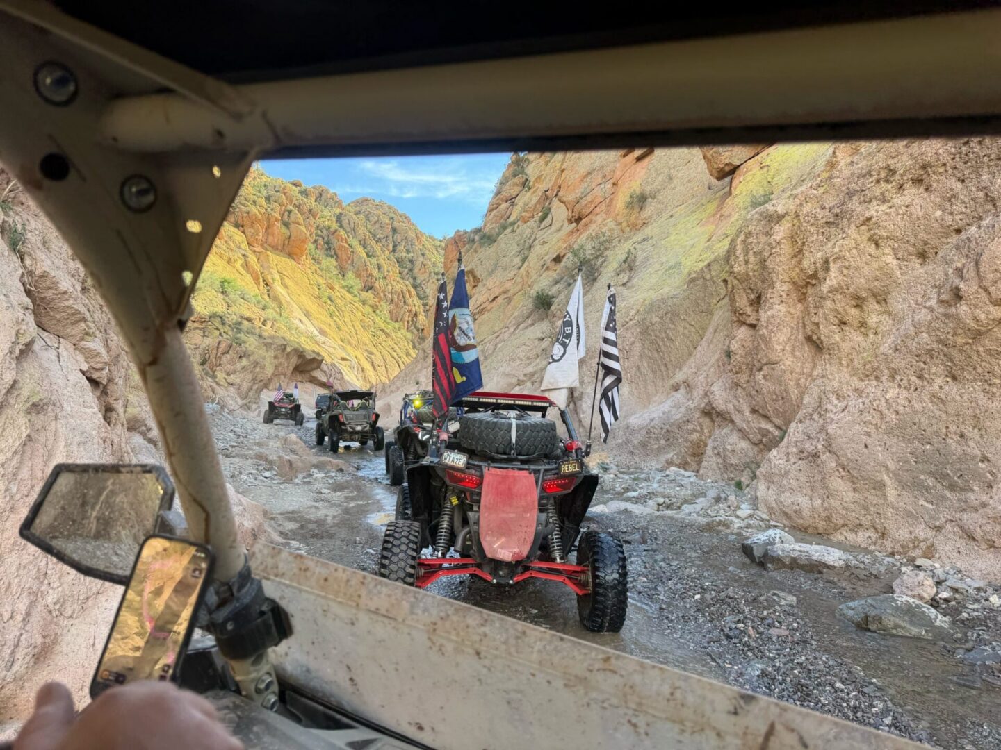 UTVs driving through rocky desert canyon