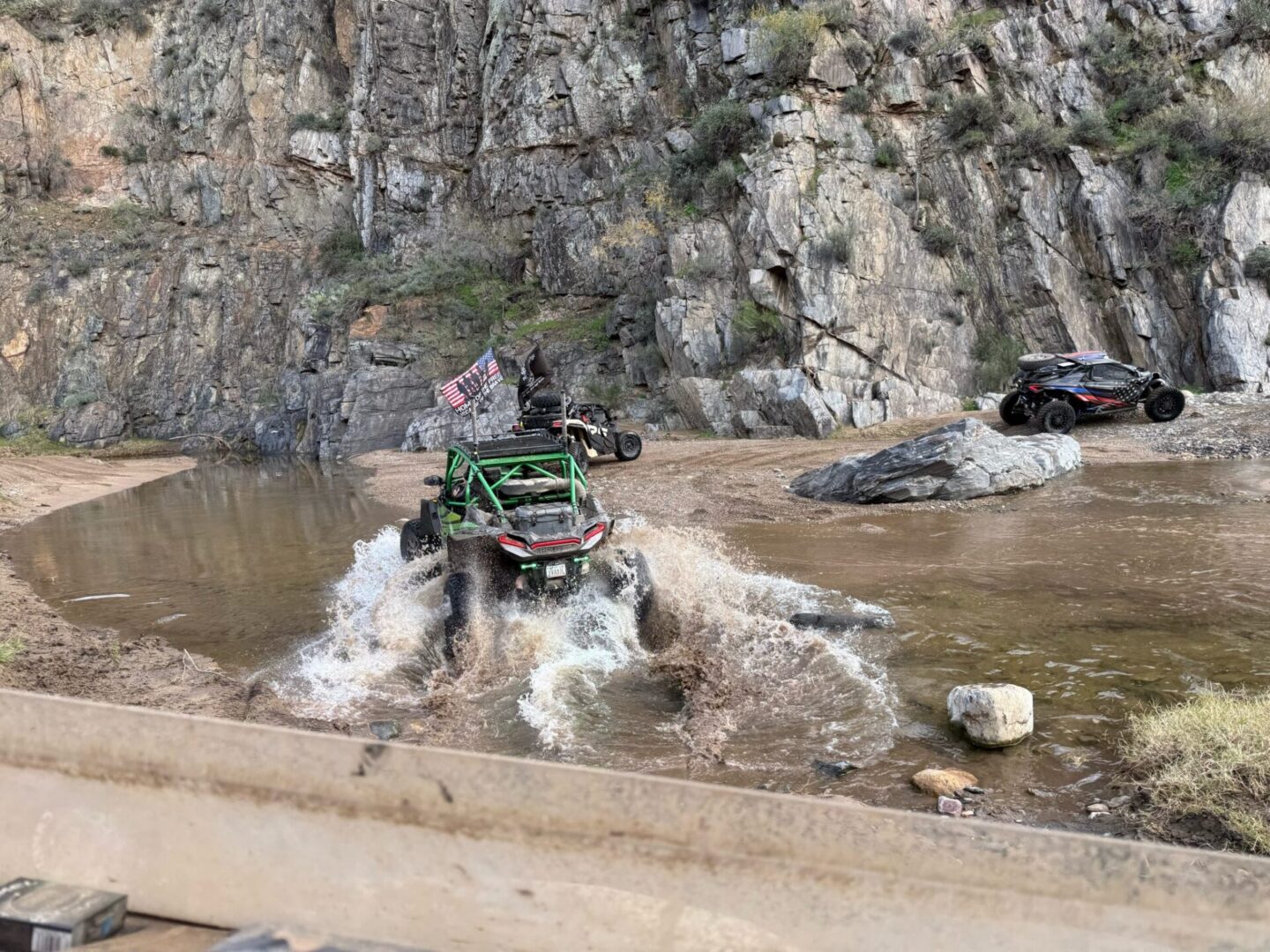 Off-road UTVs splashing through canyon stream