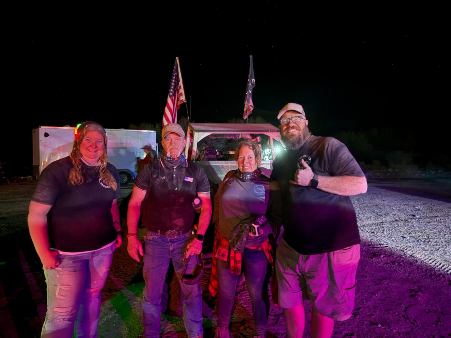 Group of four people by truck with flags