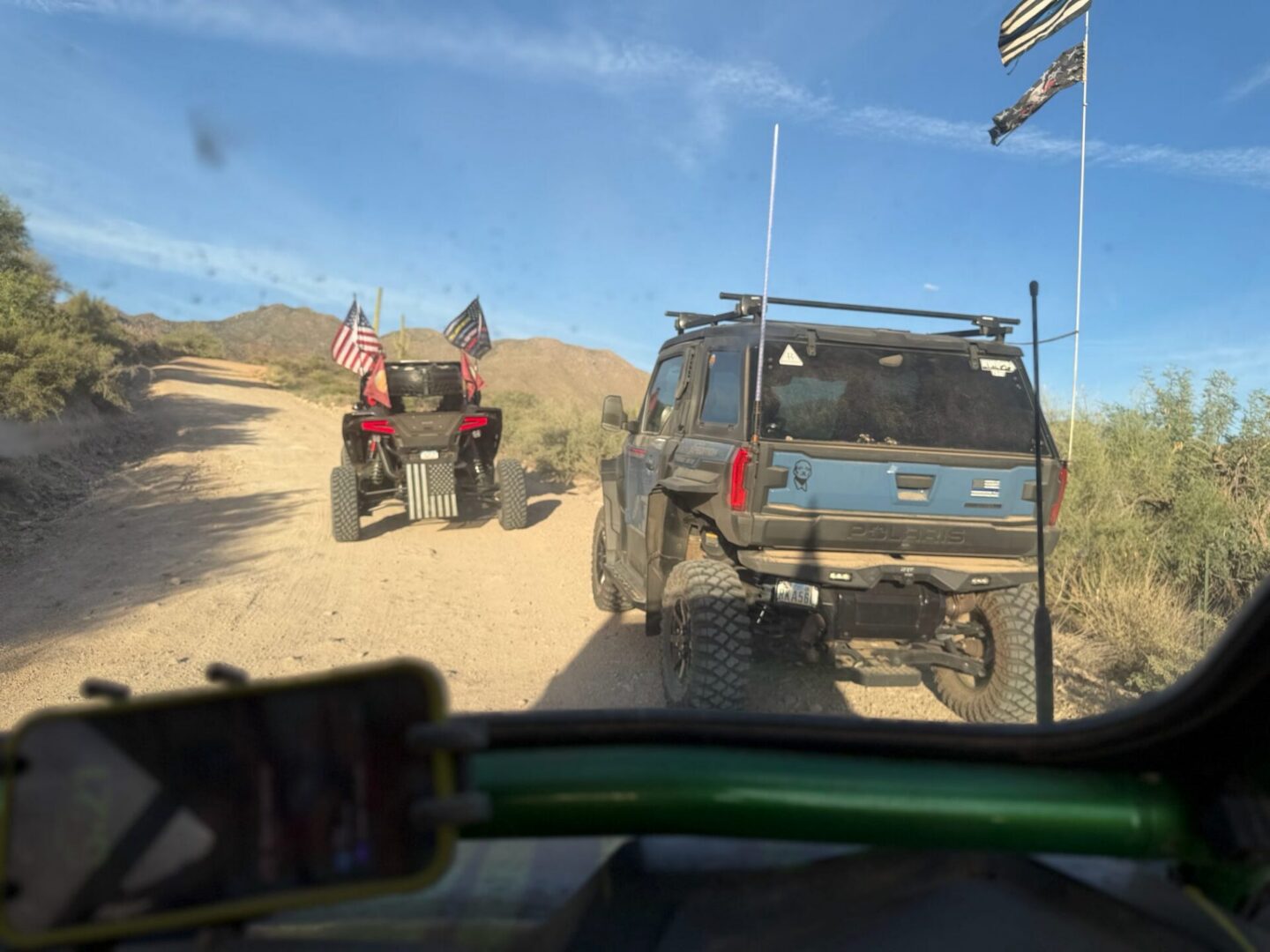 Off-road vehicles with flags on desert trail