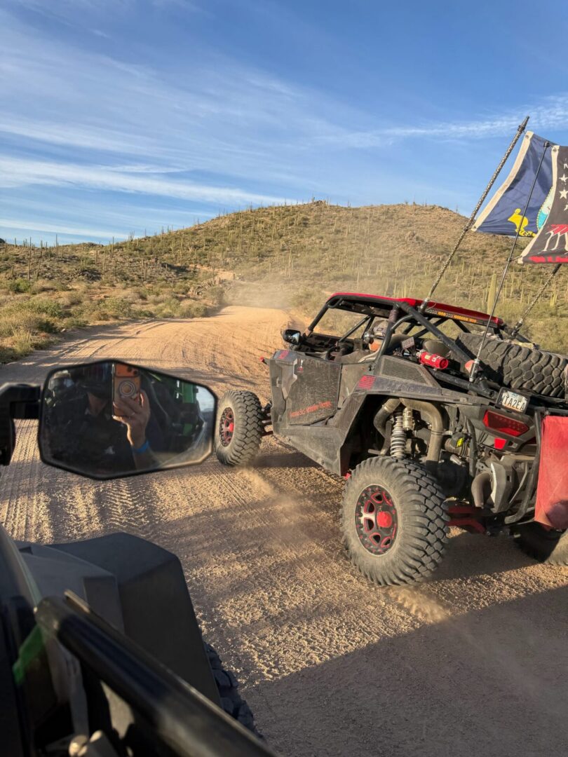 Off-road UTV with flags on dusty desert trail