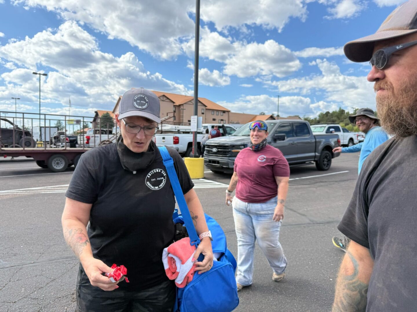 Three people talking in sunny parking lot