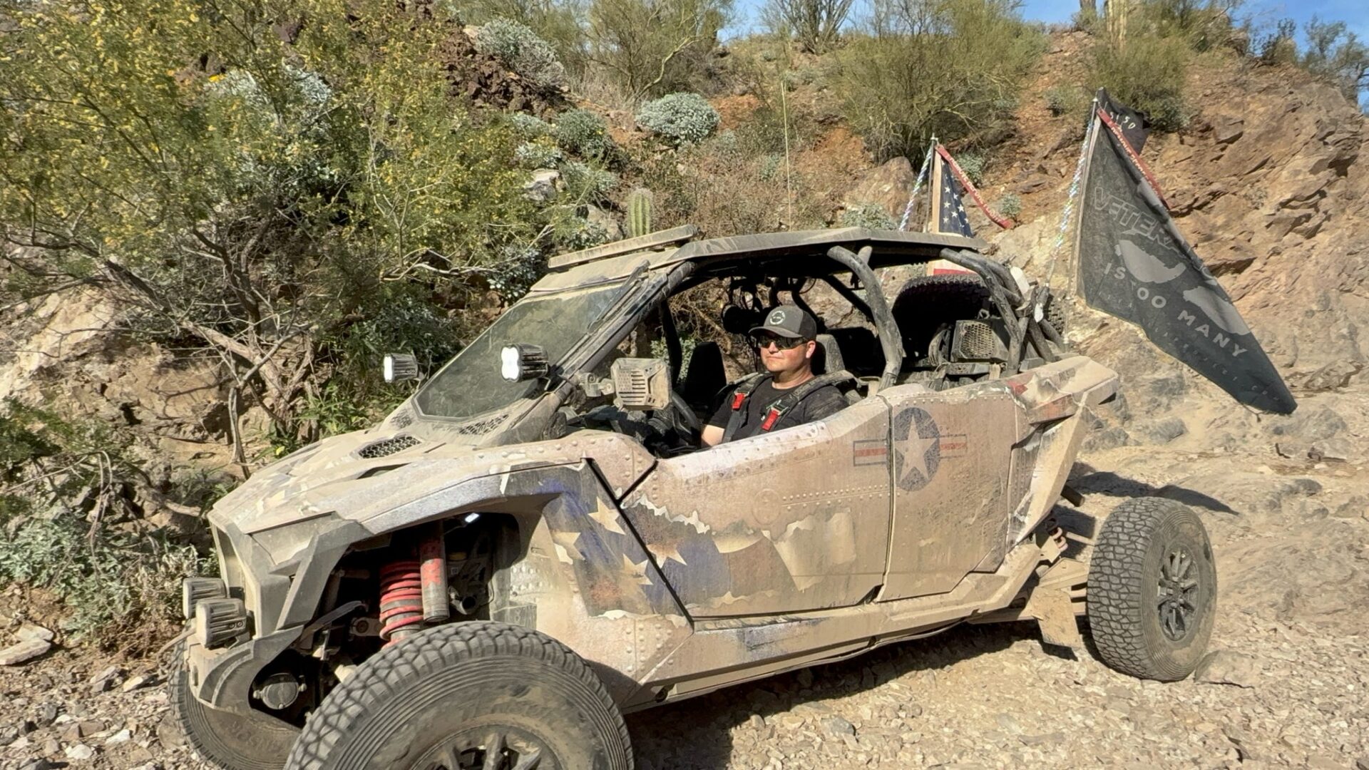 Muddy off-road UTV with driver and flags