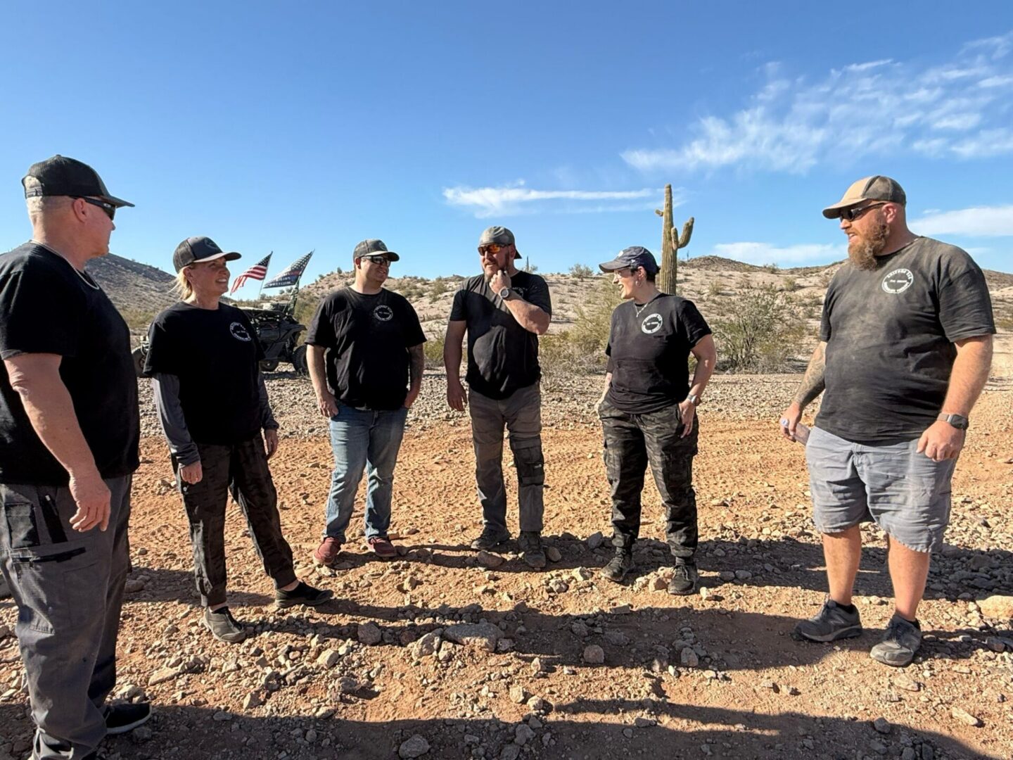 Six people standing in desert landscape