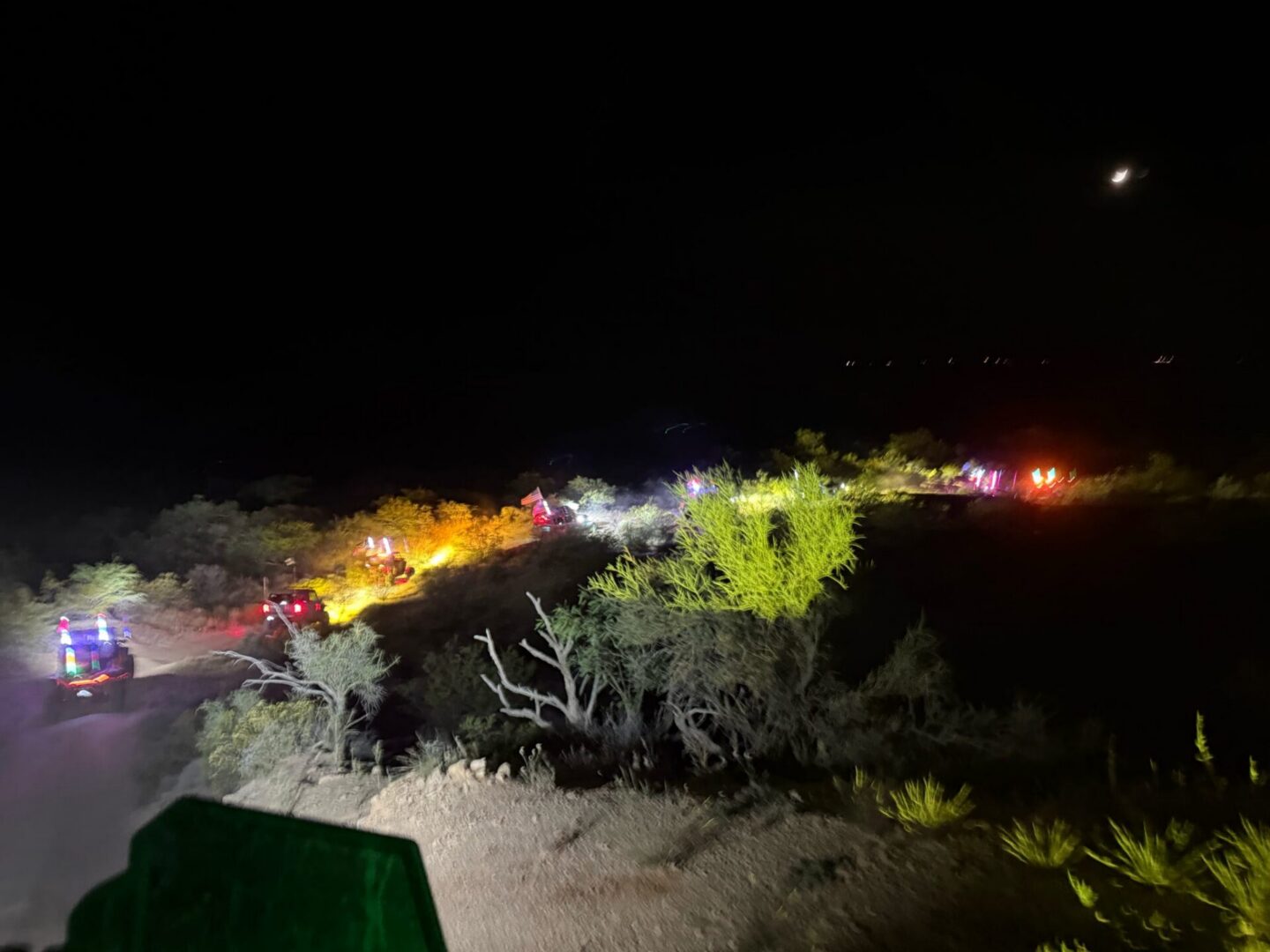 Emergency vehicles with flashing lights on desert road