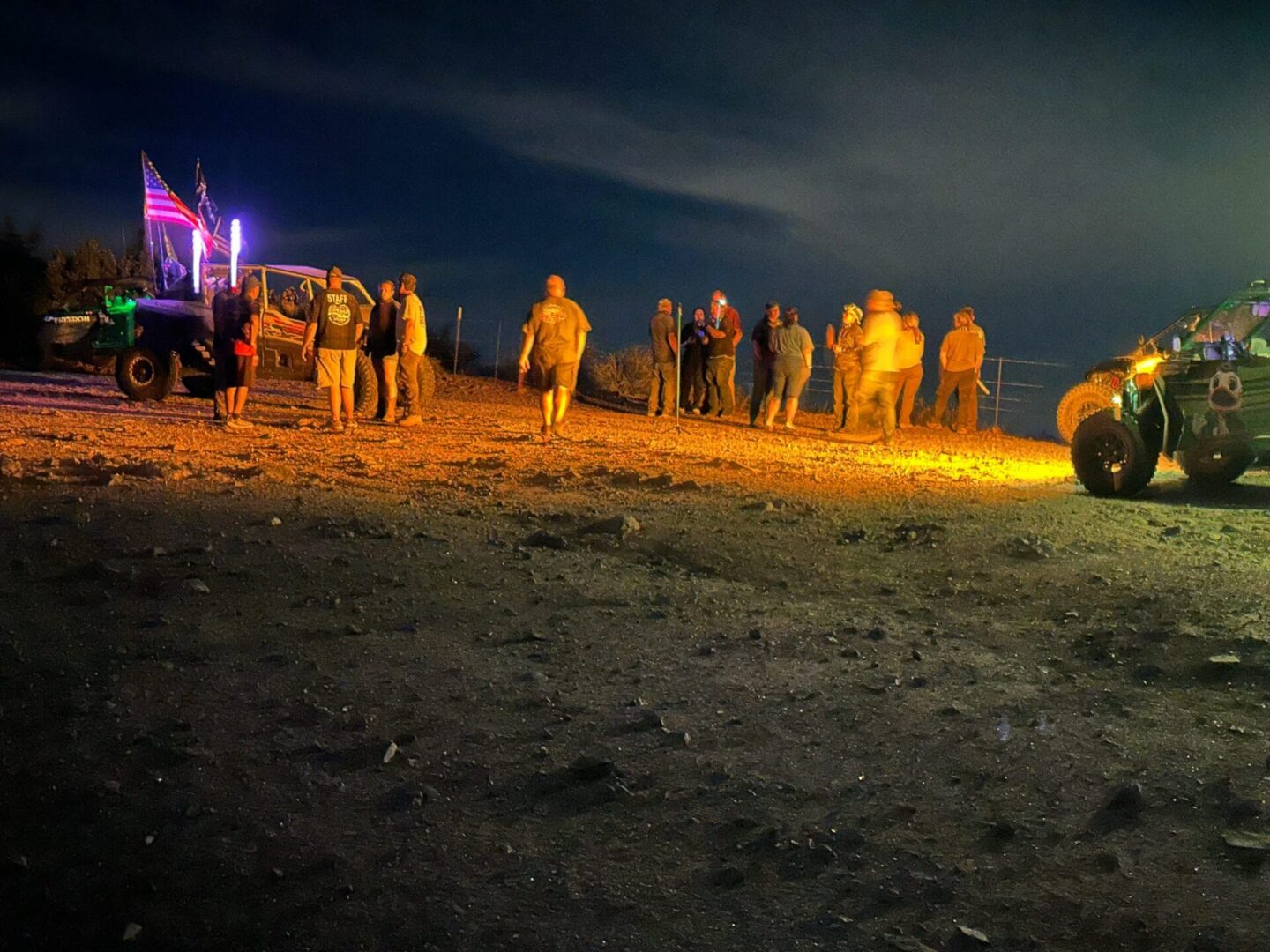 Group of people near illuminated off-road vehicles