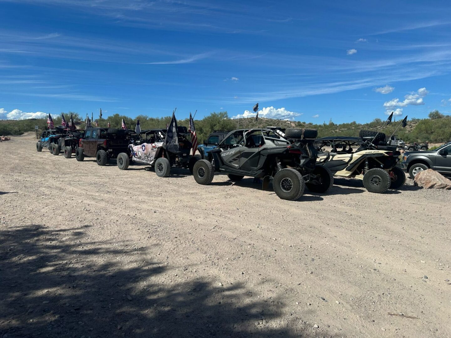 Line of off-road UTVs parked on dirt
