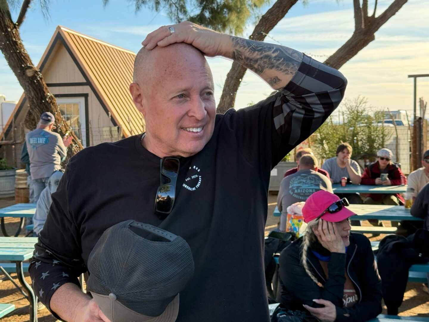 Bald smiling man with tattoo at picnic