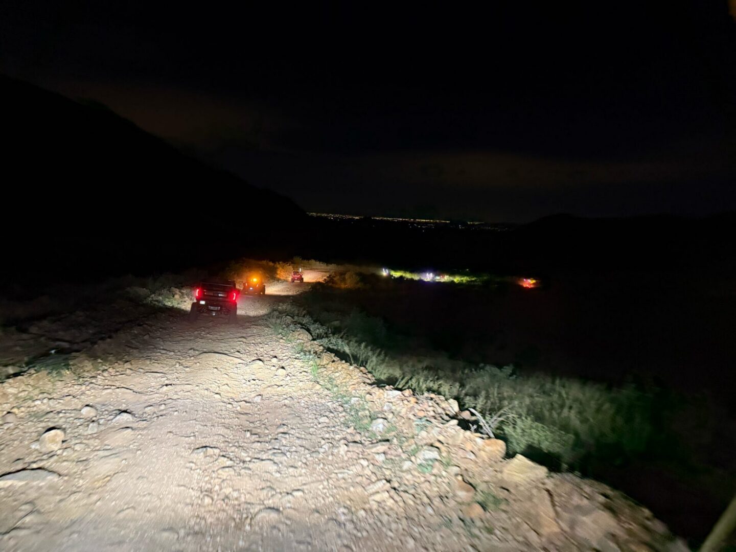 Jeep convoy driving on rocky road at night