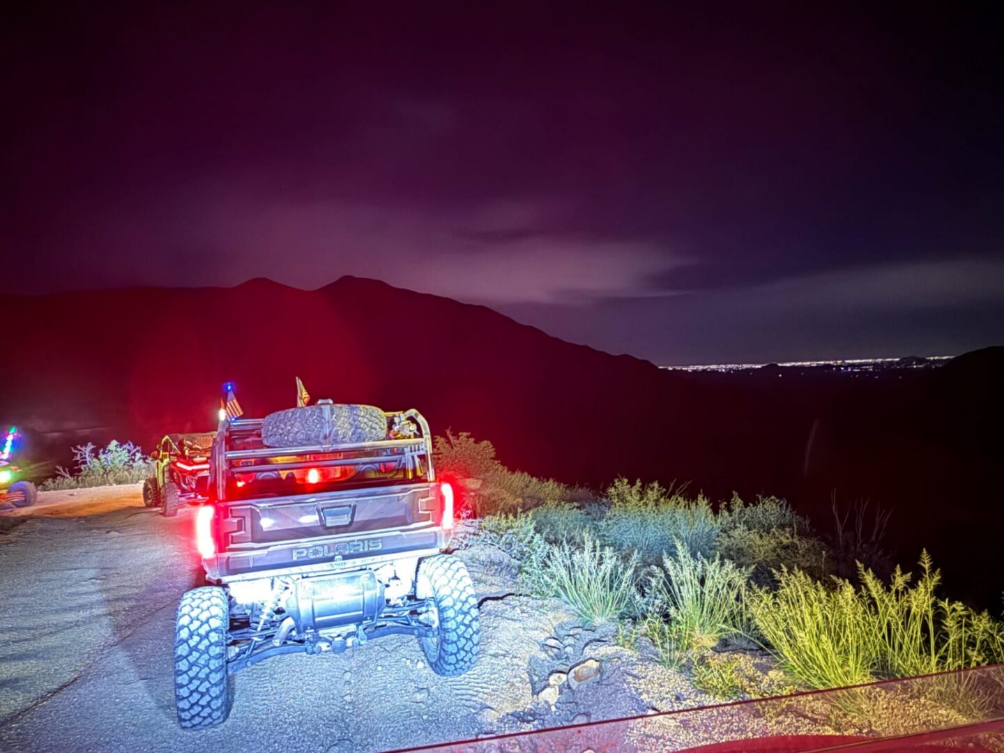 Lifted truck parked on mountain road at night