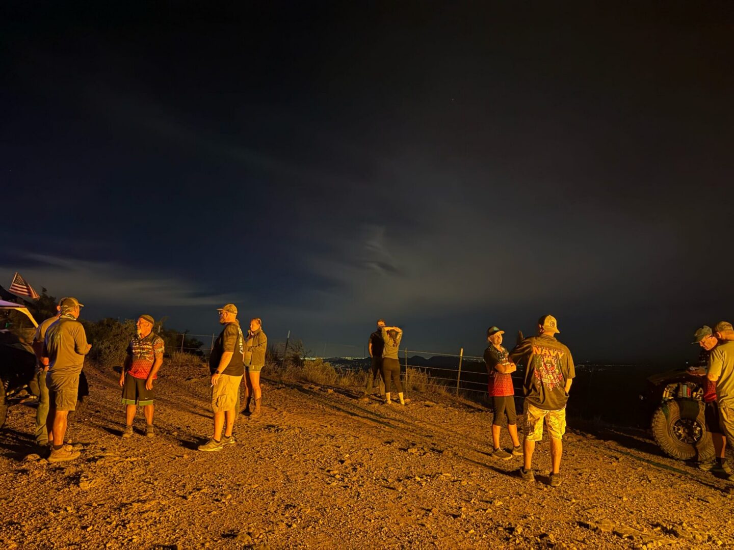 People gathered on rocky hilltop at night