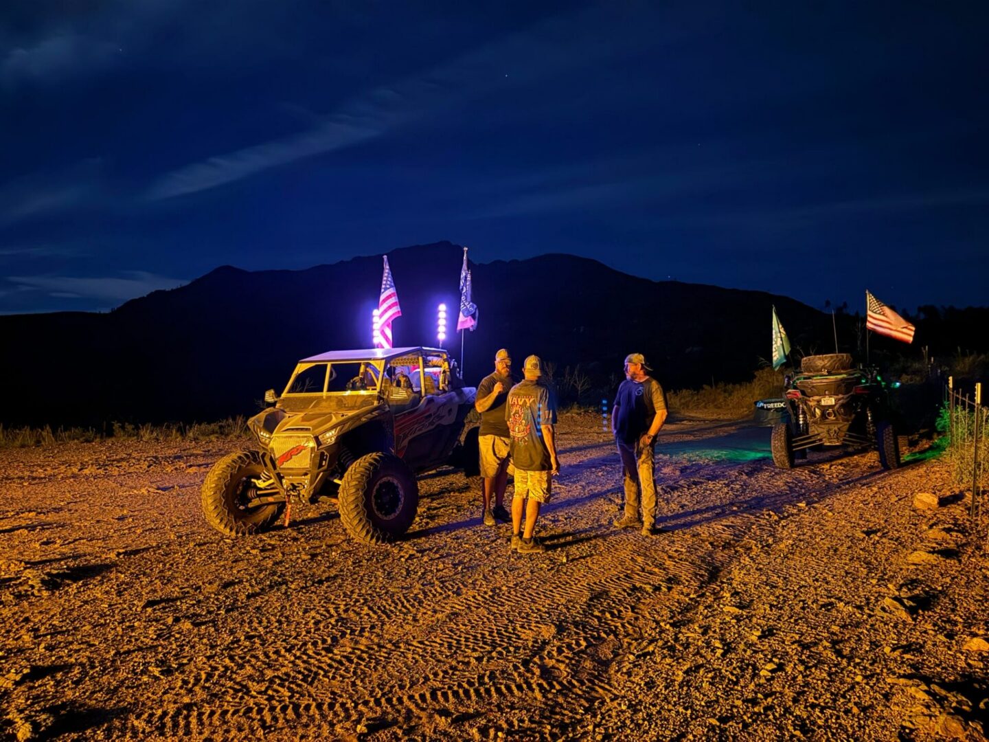 Off-road vehicles with American flags at night