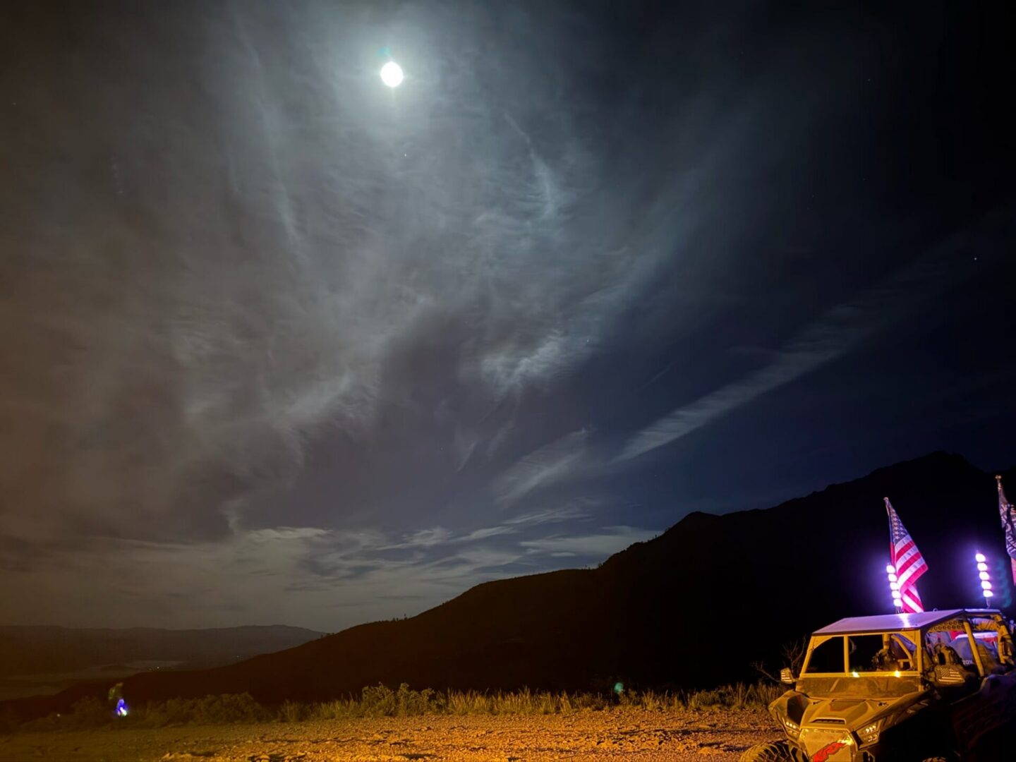 Moonlit mountains and vehicle with American flags