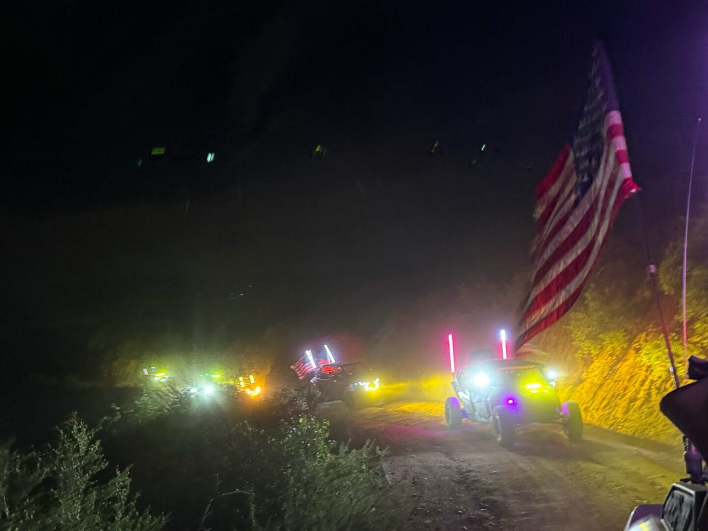Nighttime off-road convoy with American flag