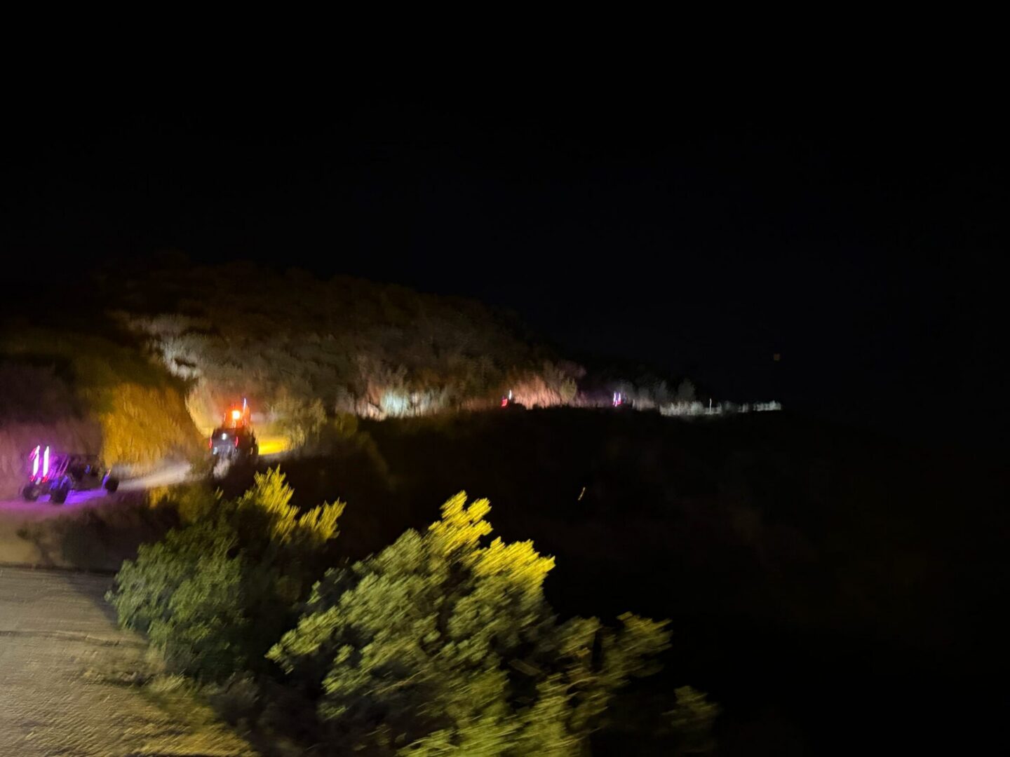 Flashing emergency vehicles on dark roadside