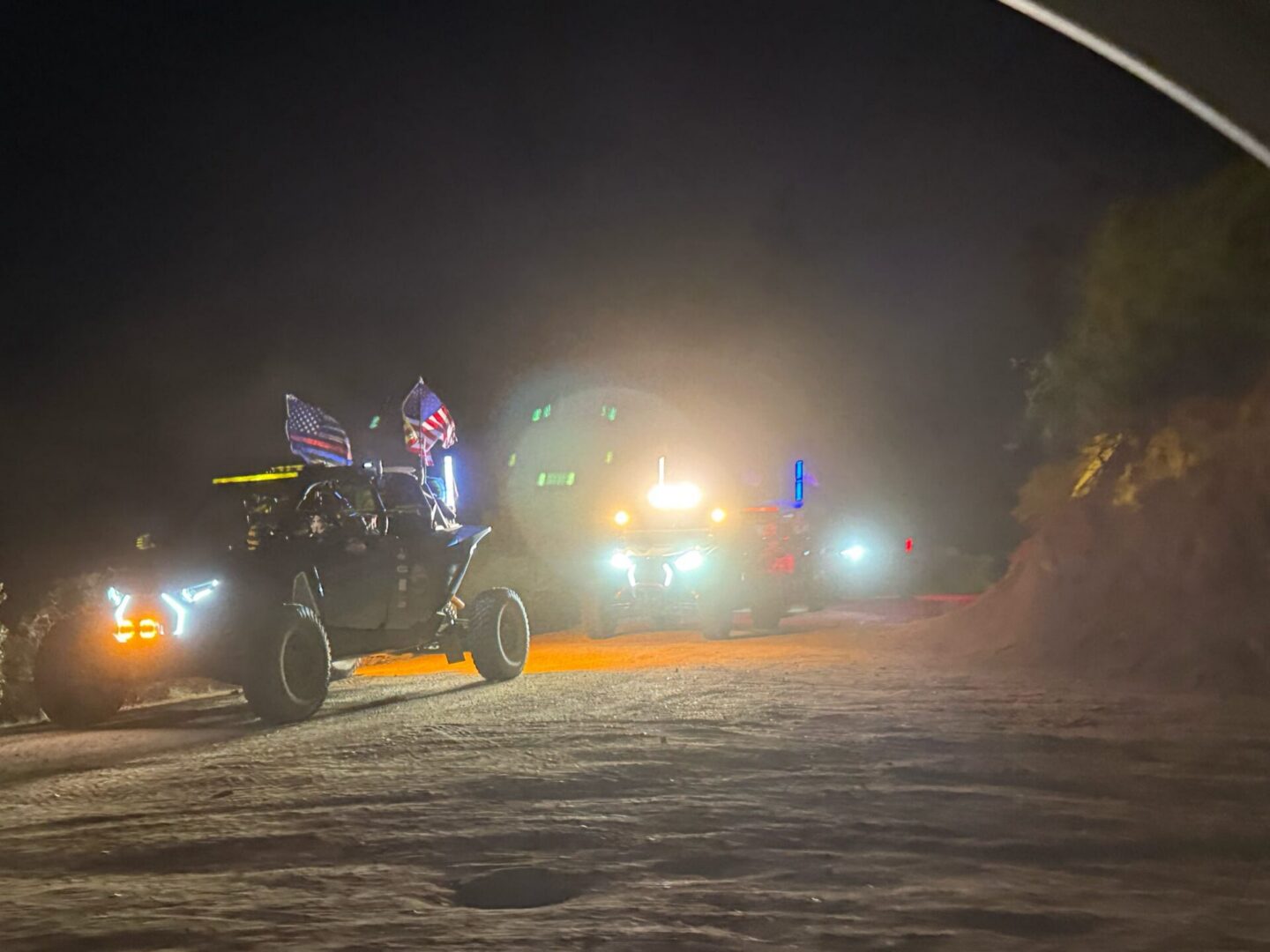 Off-road vehicles with flags driving at night