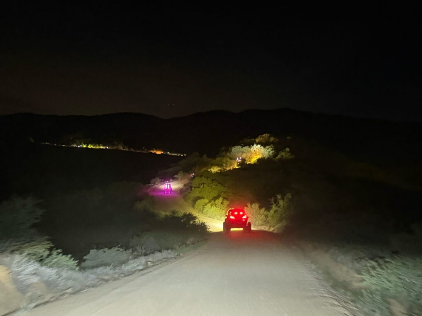 Car driving on dark rural road at night