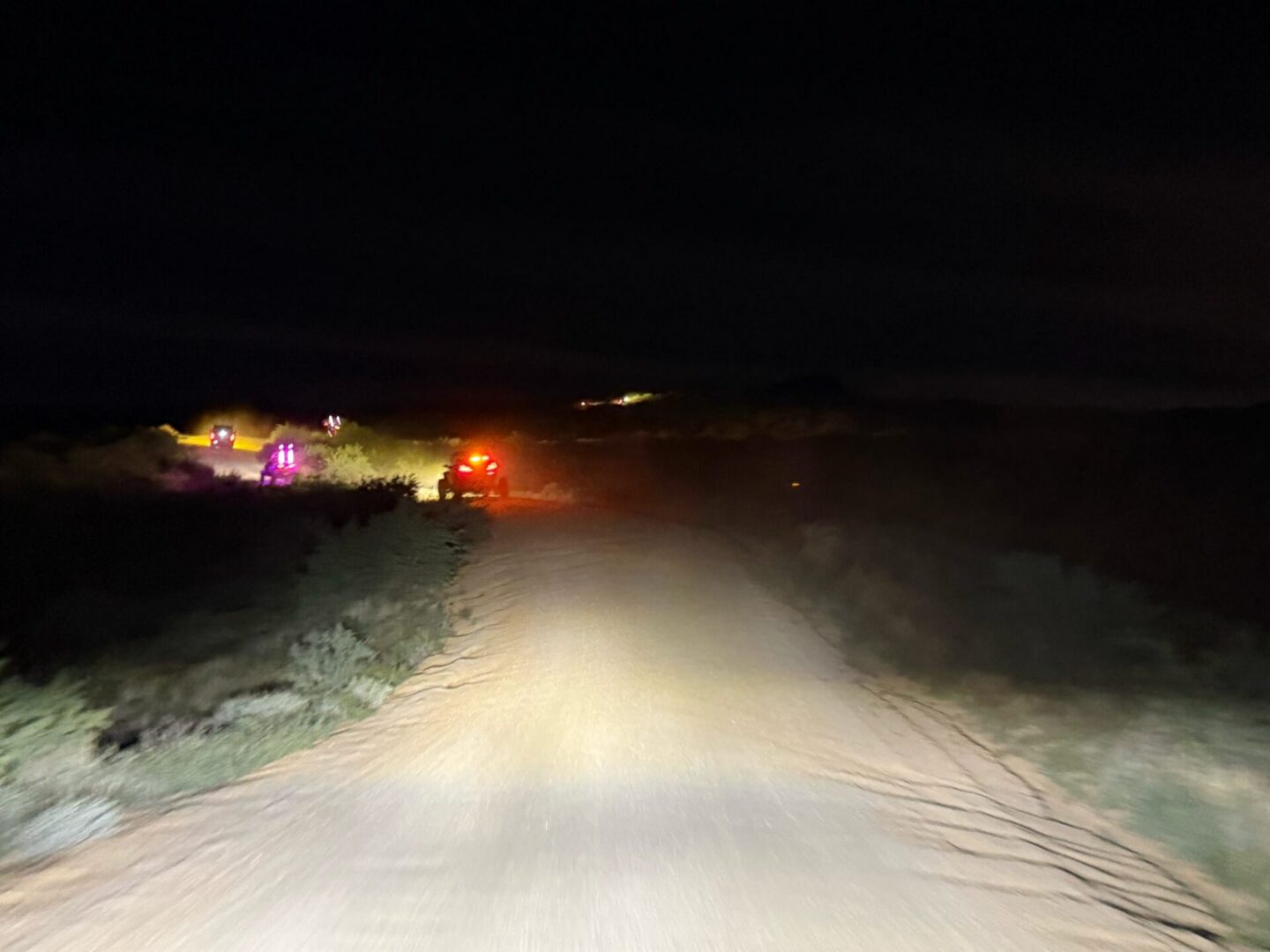 Dirt road at night with flashing vehicles