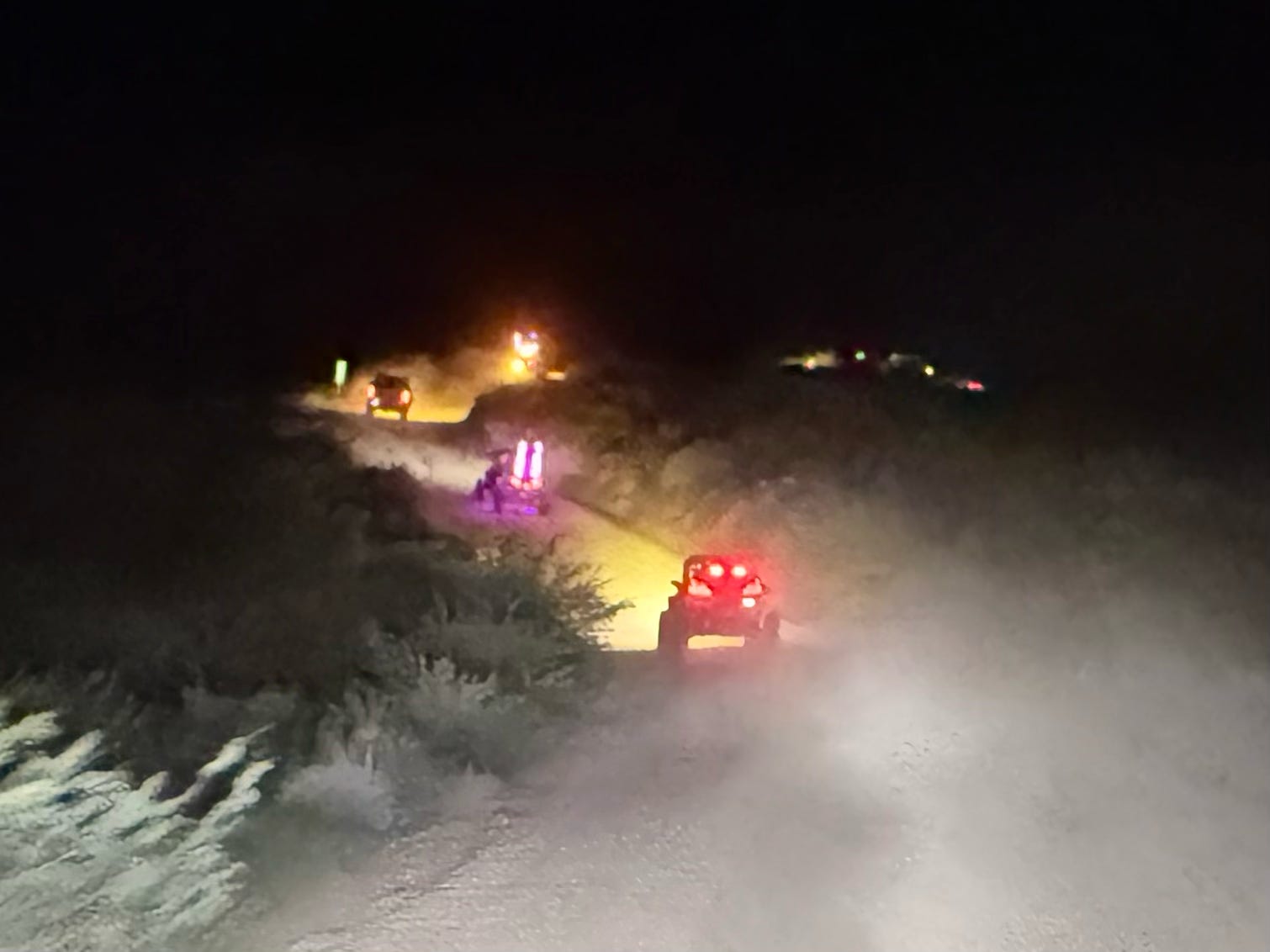 Off-road vehicles driving on desert trail at night