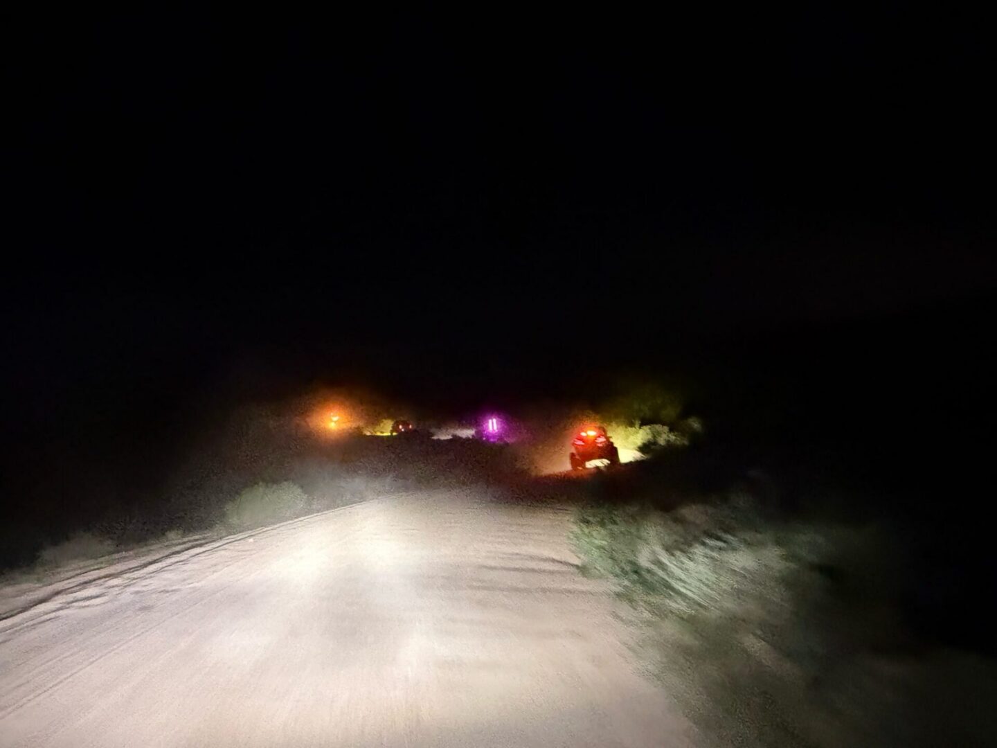 Headlights illuminating dirt road at night