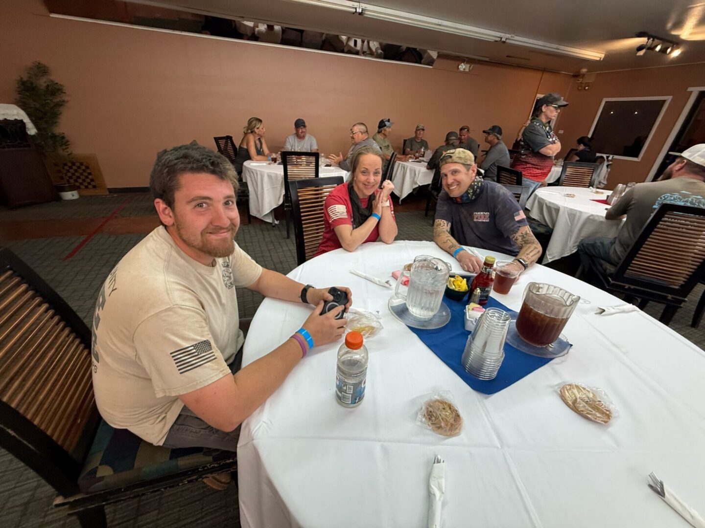 Three friends smiling around a dining table