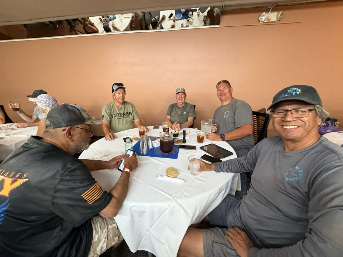 Group of men smiling around restaurant table