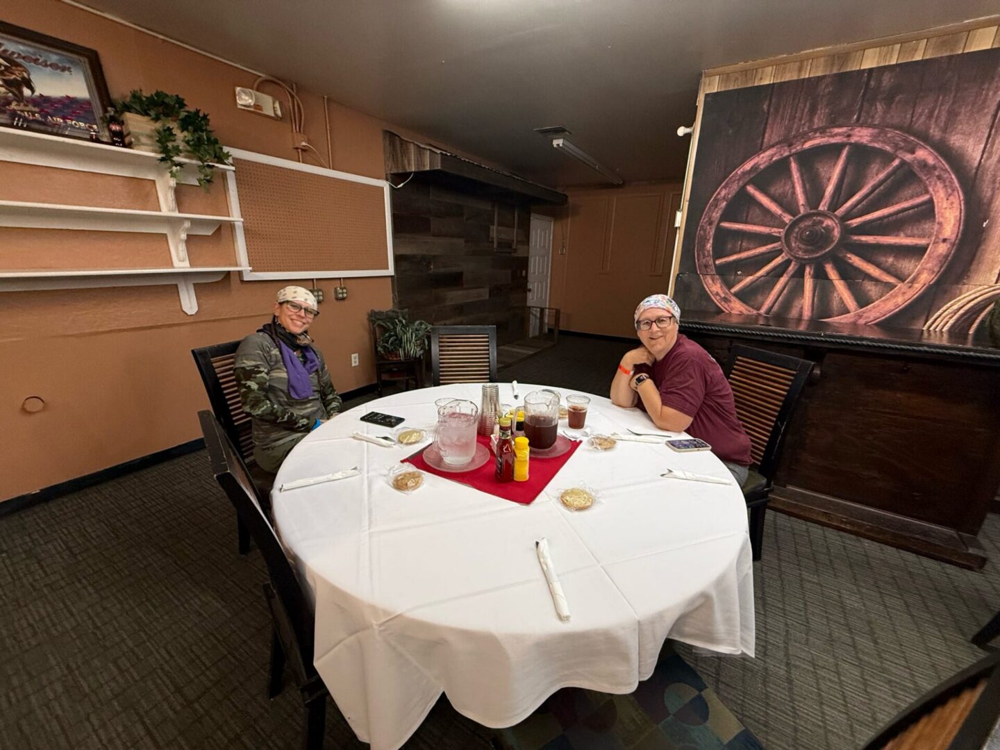 Two diners seated at round table with centerpiece